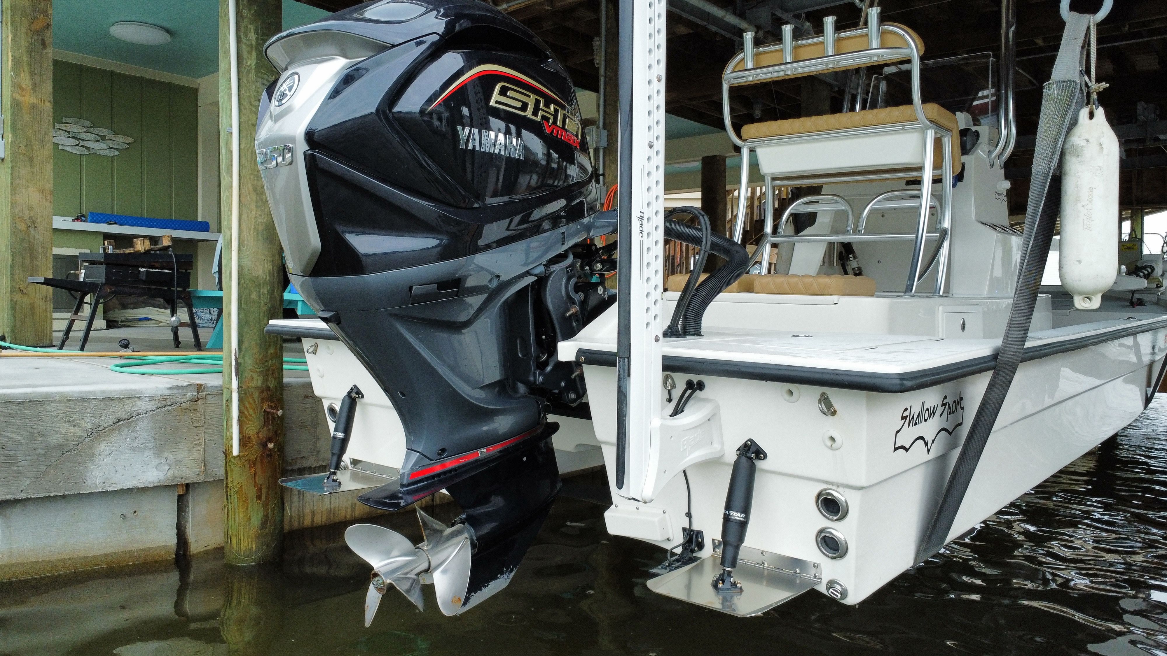 A 2025 Shallow Sport 24 Sport boat with a Yamaha outboard motor, docked at a pier.