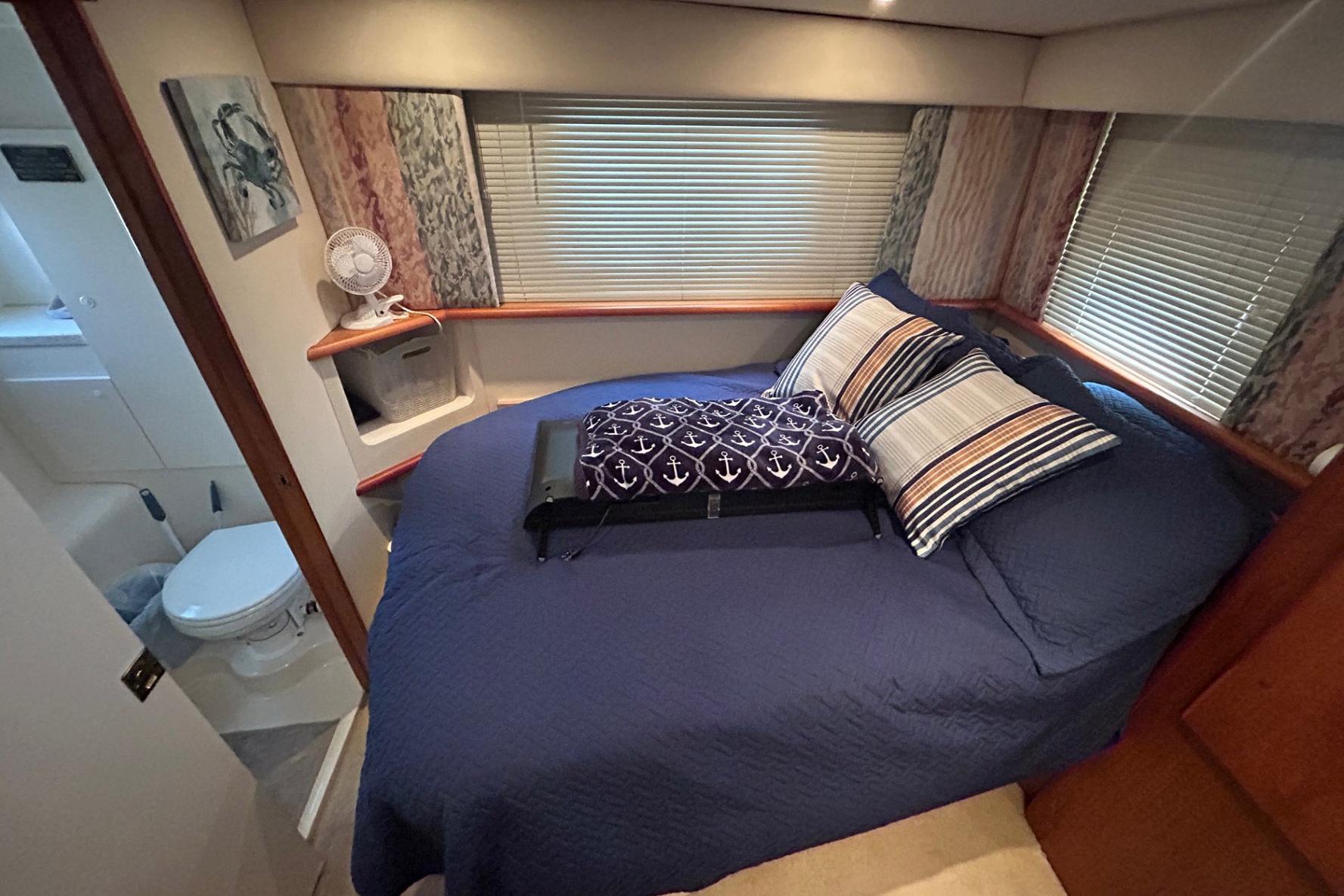 Cozy bedroom in 2000 Silverton 352 Motor Yacht with nautical-themed decor.
