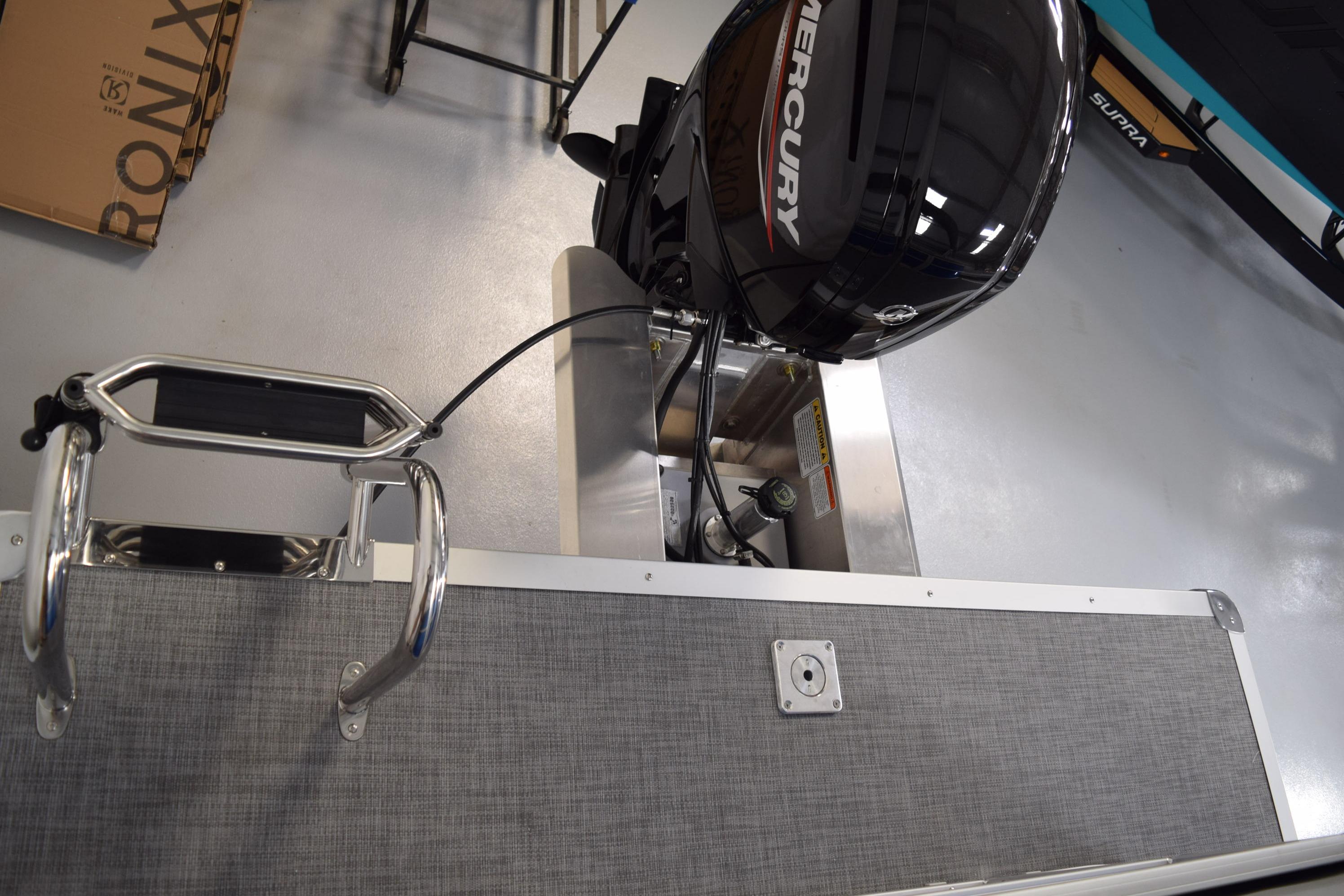 2026 Sun Tracker Party Barge 20 DLX with Mercury outboard motor in showroom.