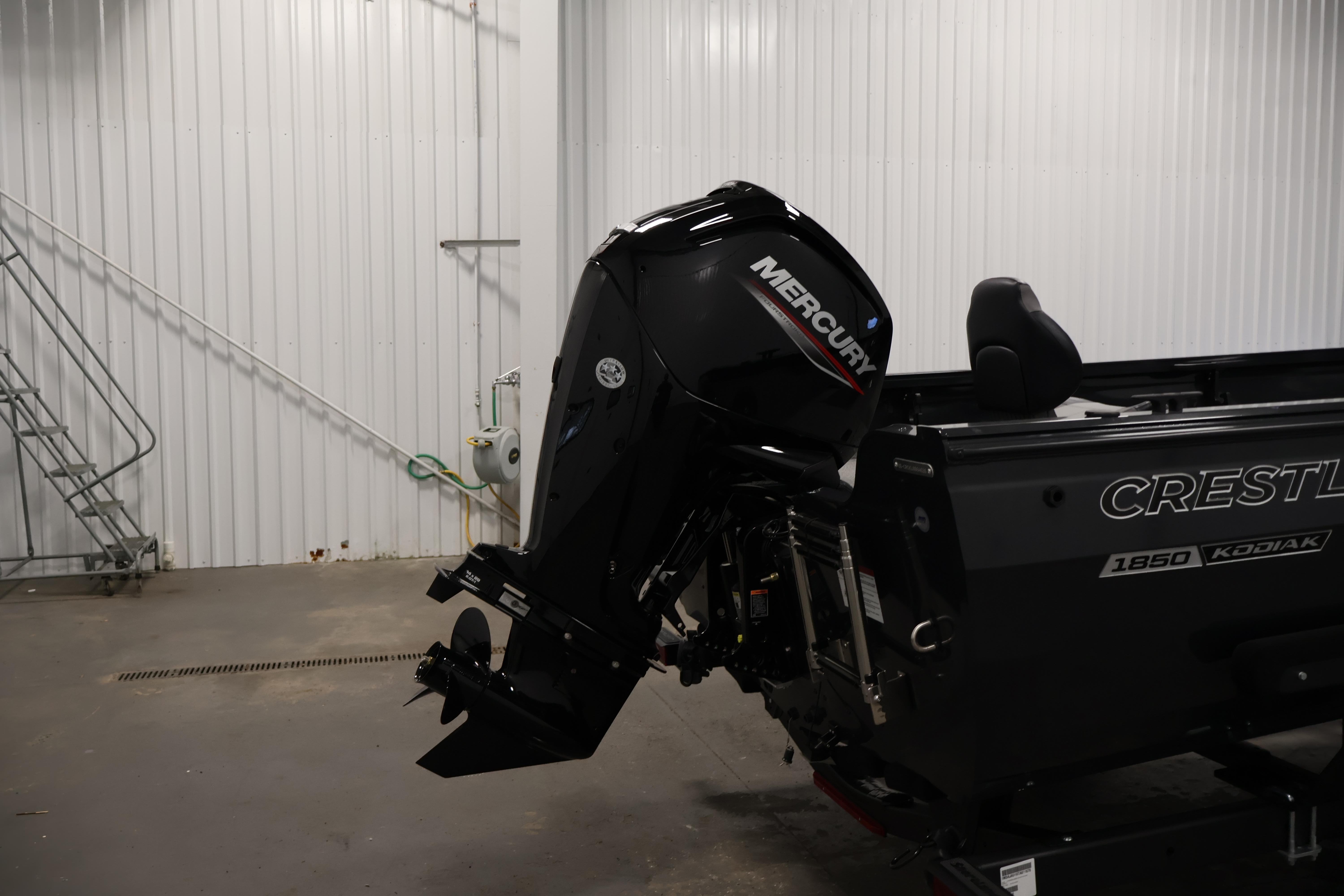 2026 Crestliner 1850 Kodiak SC boat with Mercury outboard motor in a garage.