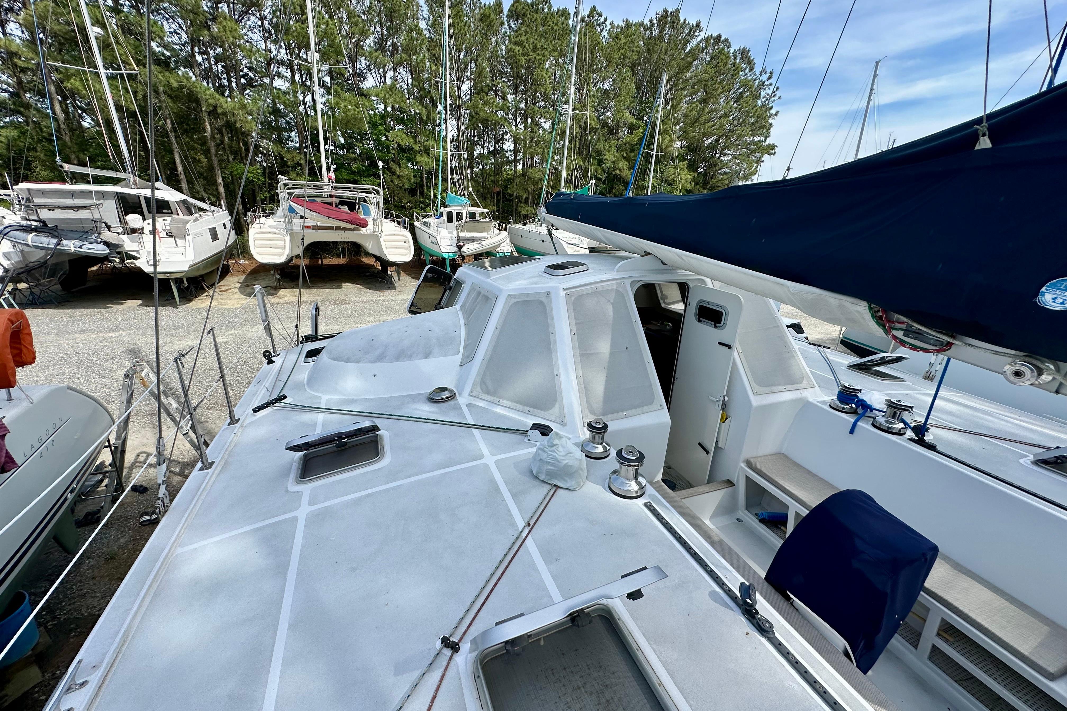 2003 Chris White Atlantic 42 sailboat on land, surrounded by trees and other boats.