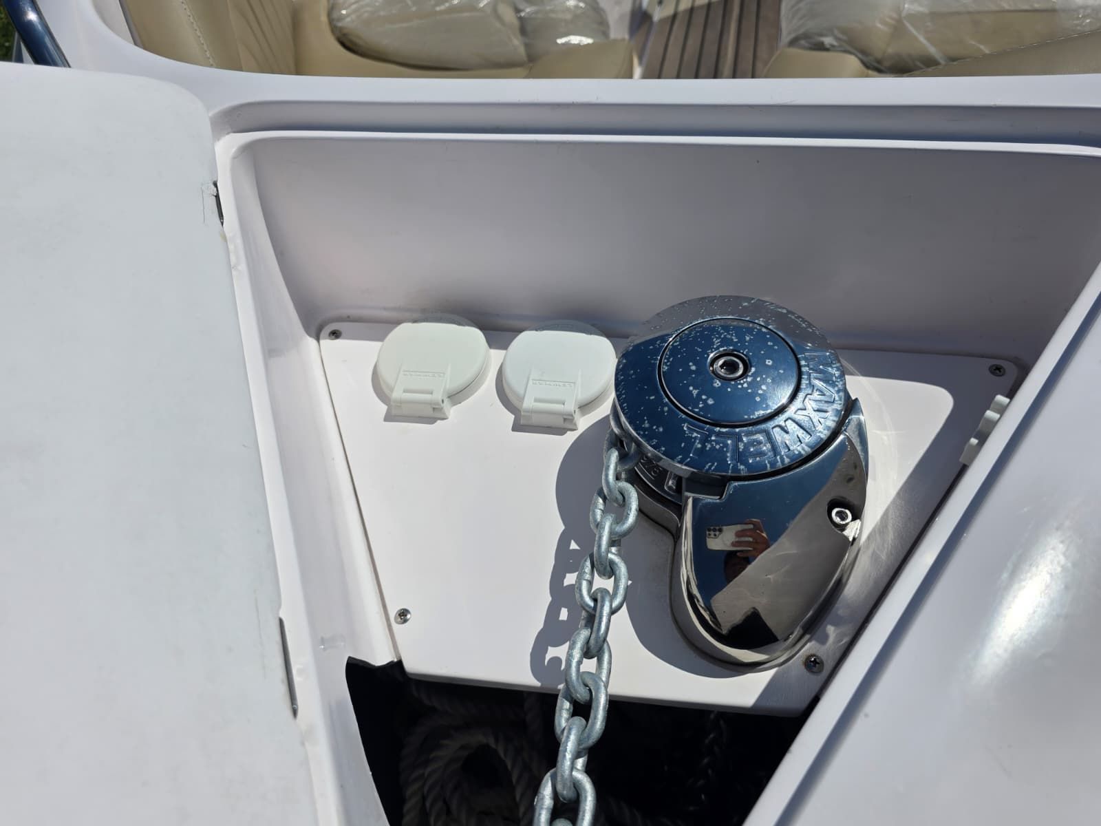 Close-up of an anchor windlass on a boat, with chain and covers.