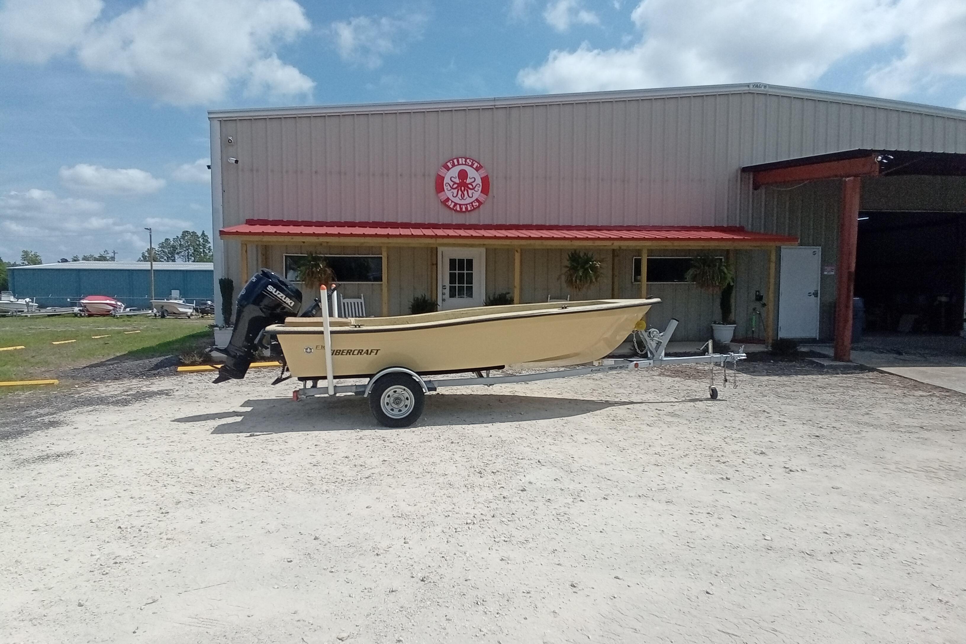Fibercraft F16 boat, 2025 model, parked outside a warehouse on a sunny day.