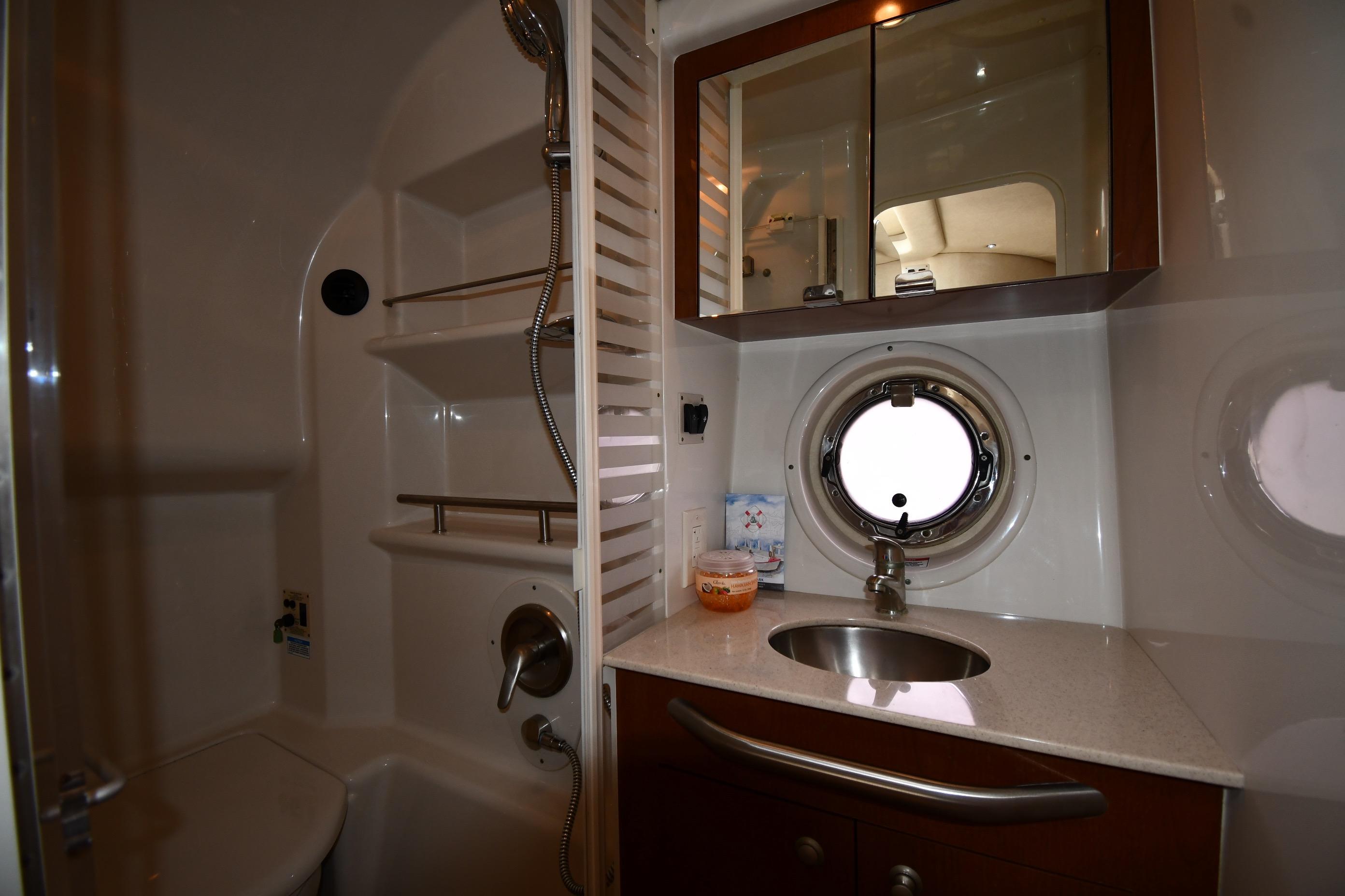 Luxurious bathroom in 2008 Sea Ray Sundancer 350 yacht with sink, mirror, and porthole window.