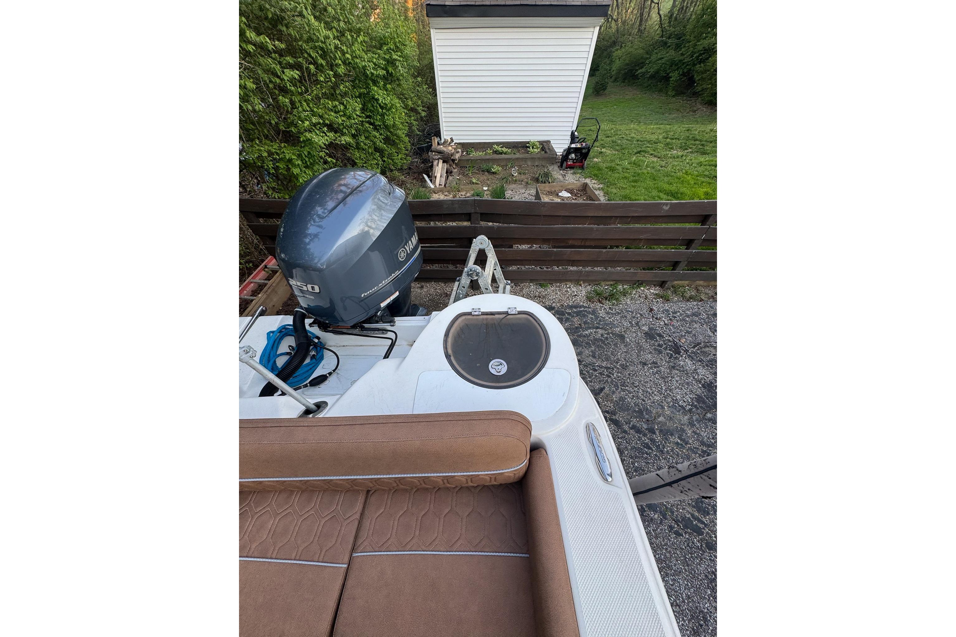 2013 Sea Fox 246 Commander boat with Yamaha outboard motor, parked near a garden shed.
