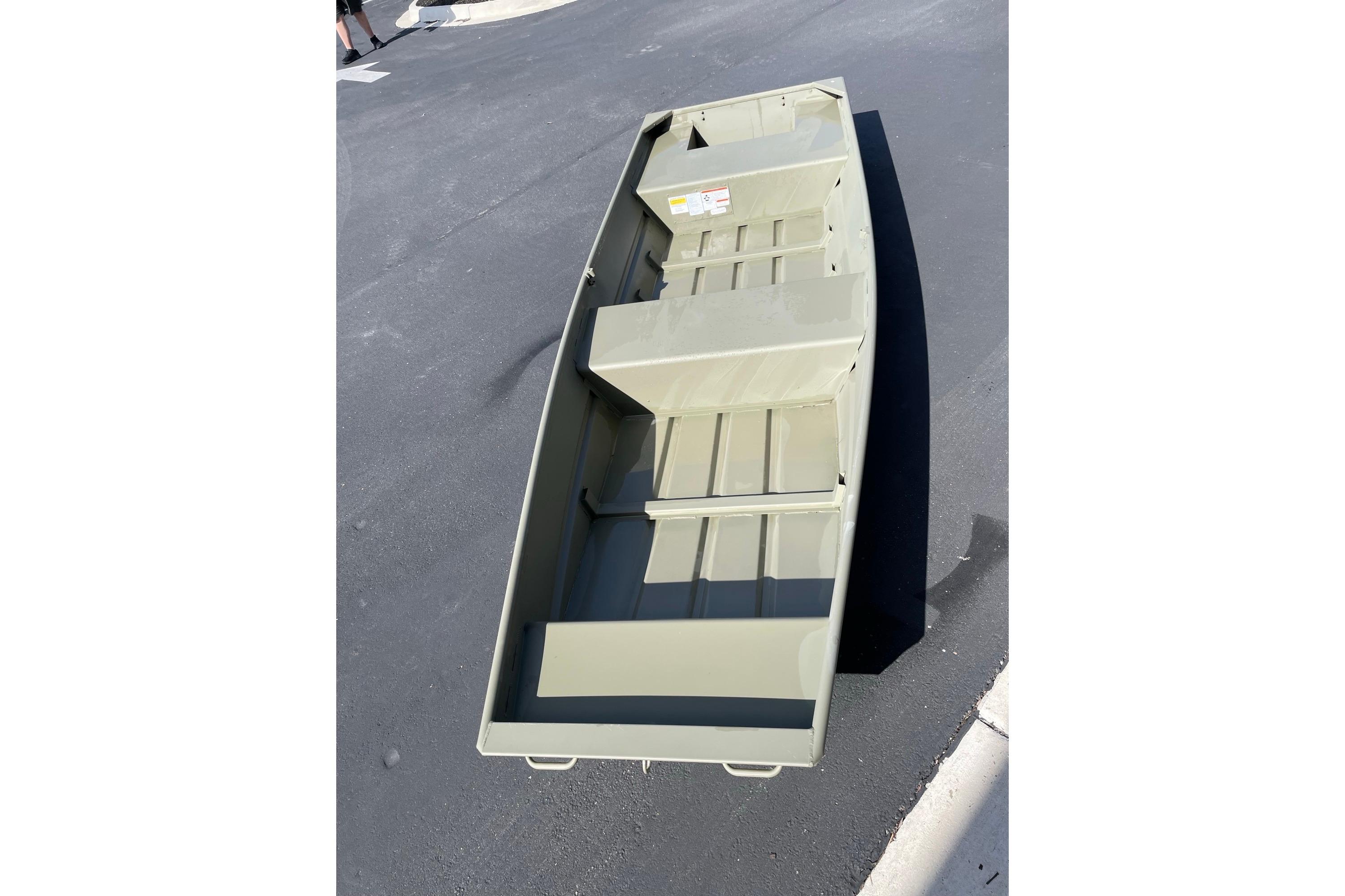 2026 Tracker Grizzly 14 Jon boat on pavement, showcasing interior layout.