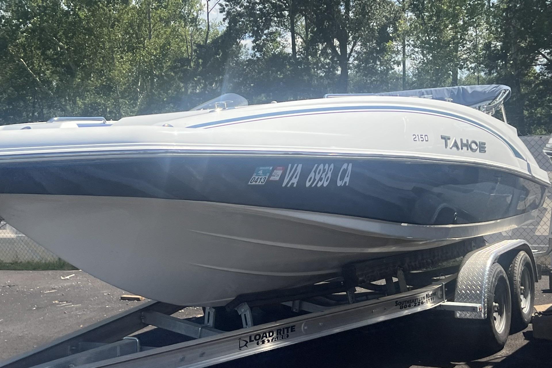 2017 Tahoe 2150 boat on trailer, parked outdoors with trees in background.