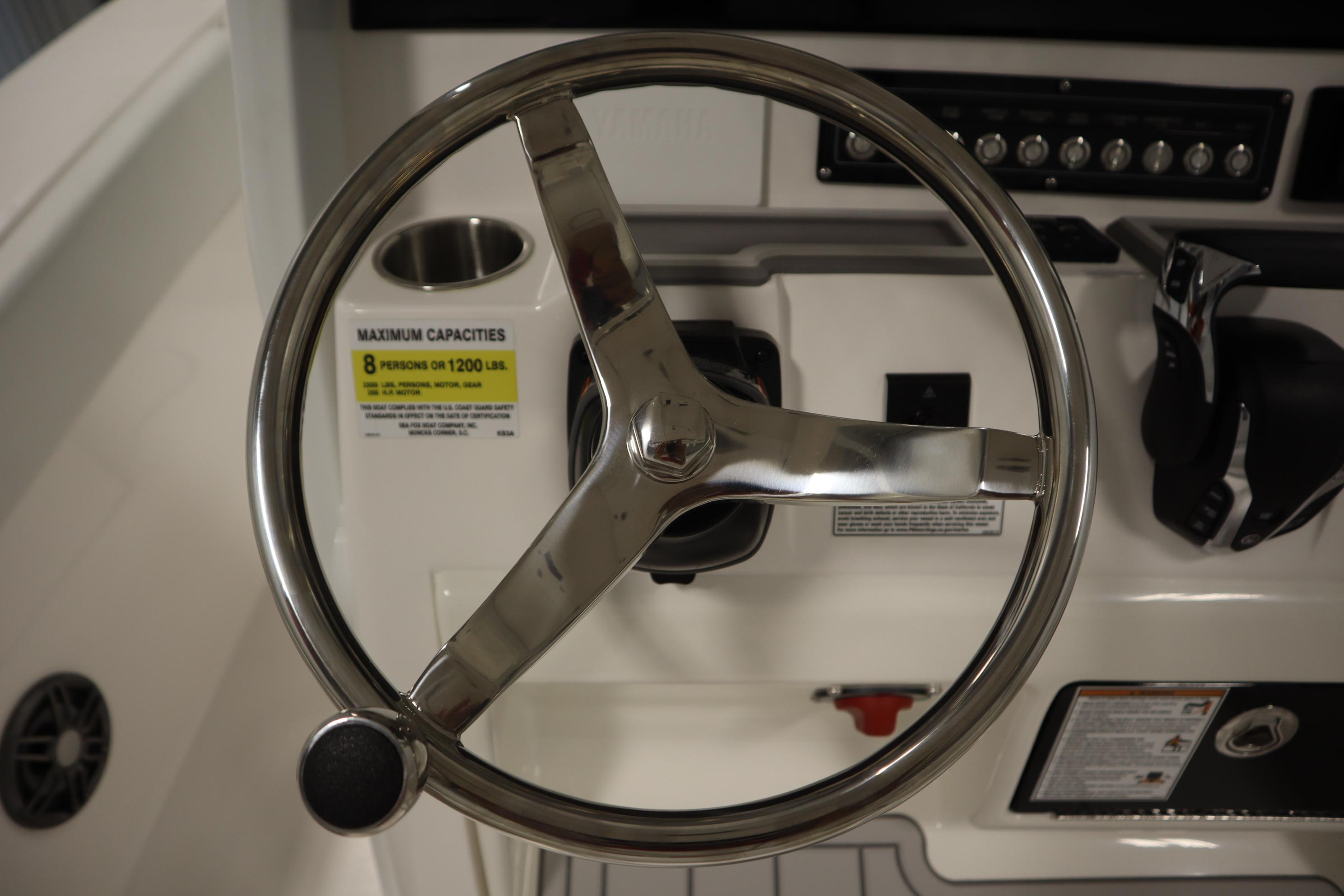 Steering wheel of 2026 Sea Fox 228 Commander boat, showcasing control panel and capacity label.
