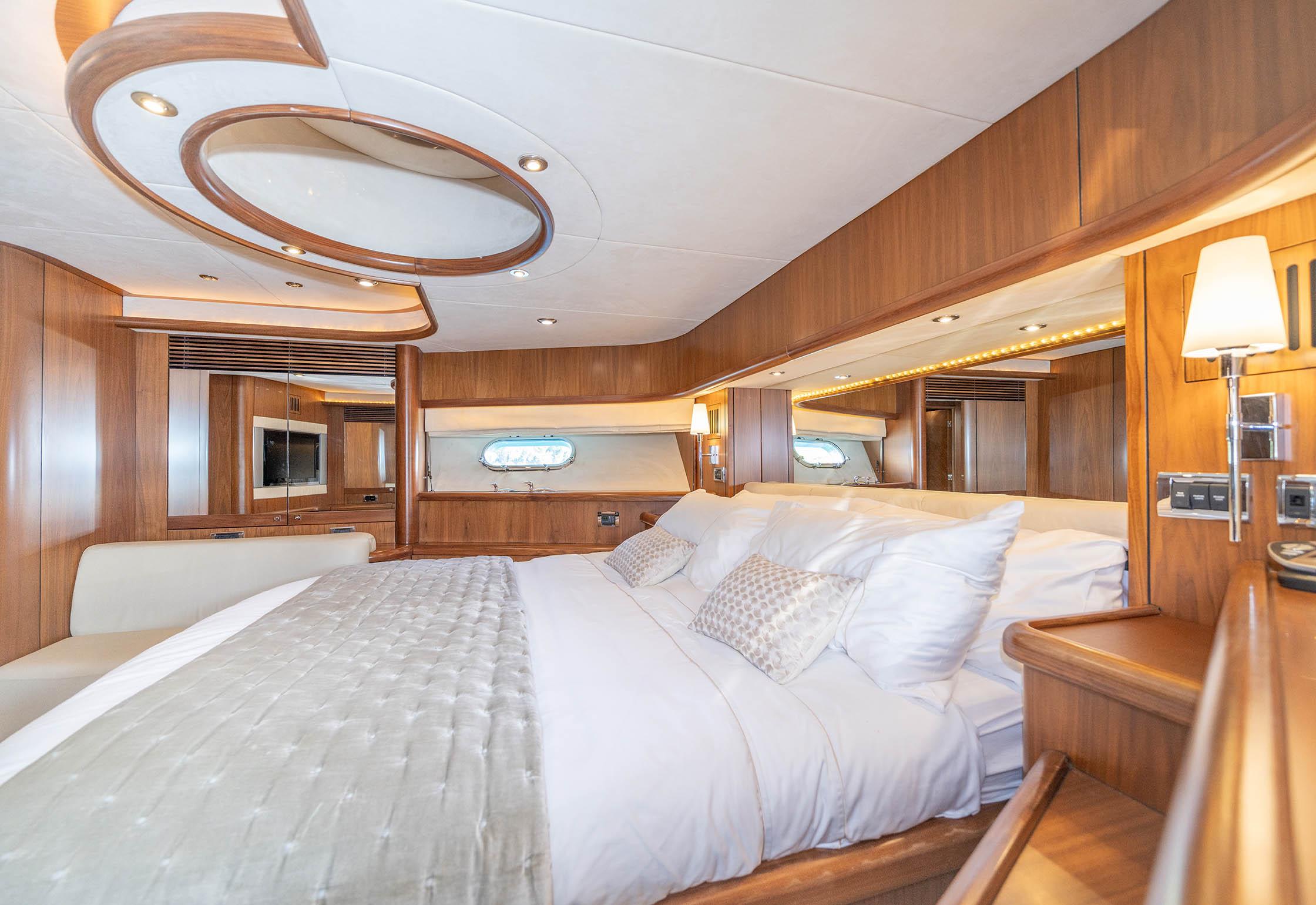 Luxurious bedroom interior of 2006 Sunseeker 82 Yacht with elegant wood finish and plush bedding.