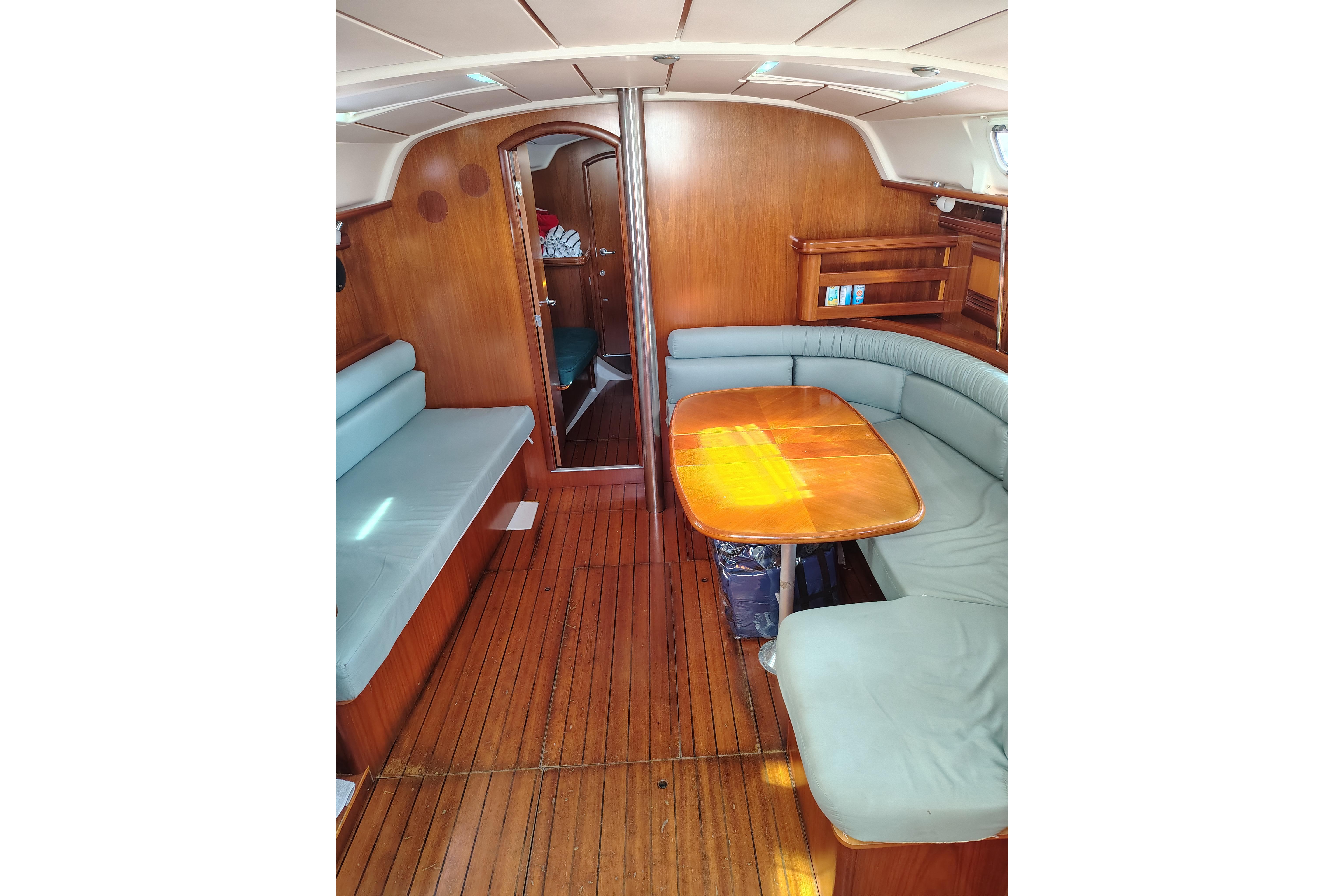 Interior of 2001 Beneteau Oceanis 411 sailboat with wooden flooring and seating area.
