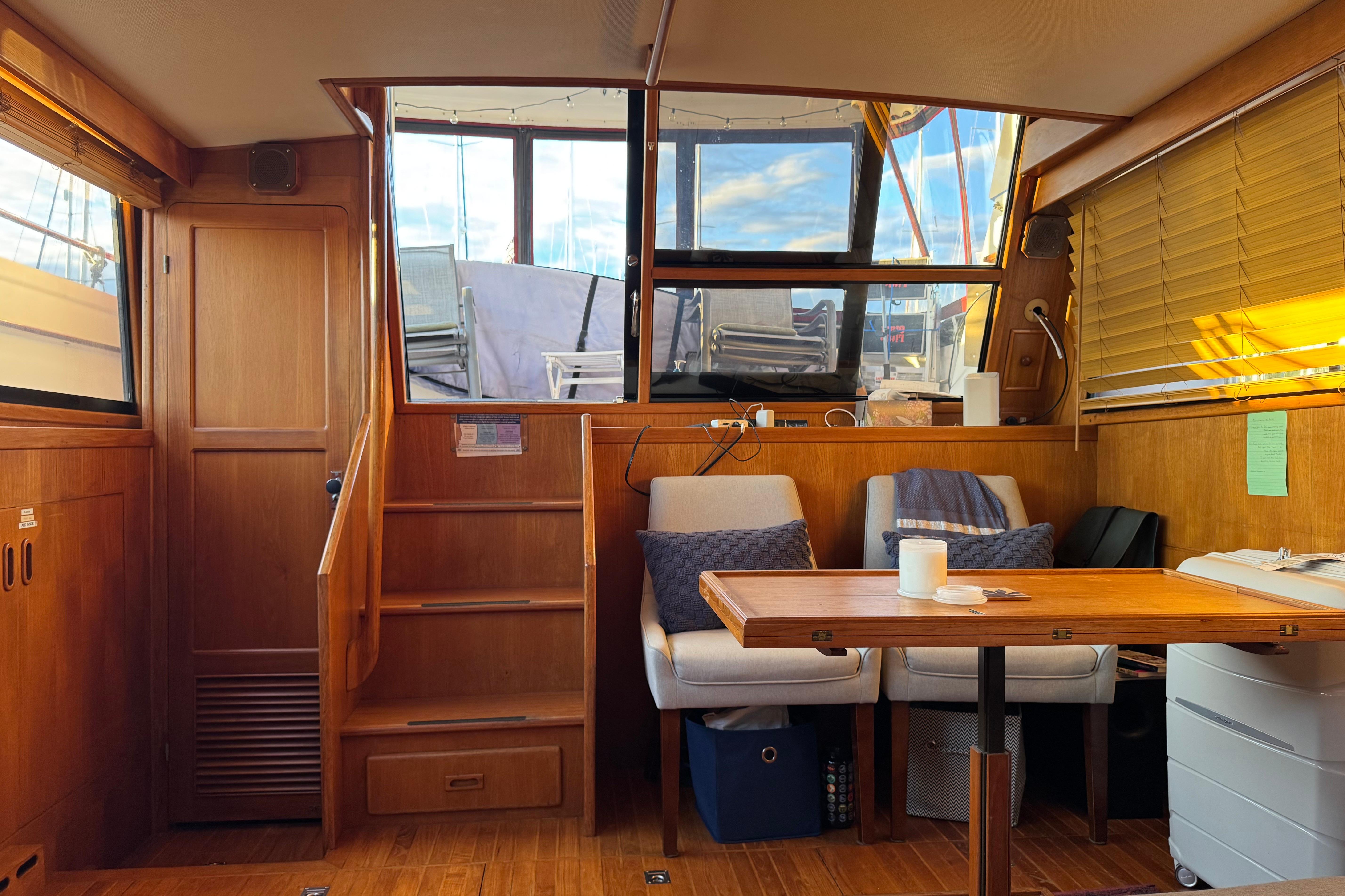 Interior of a 1987 President 37 yacht with wooden furnishings and cozy seating area.