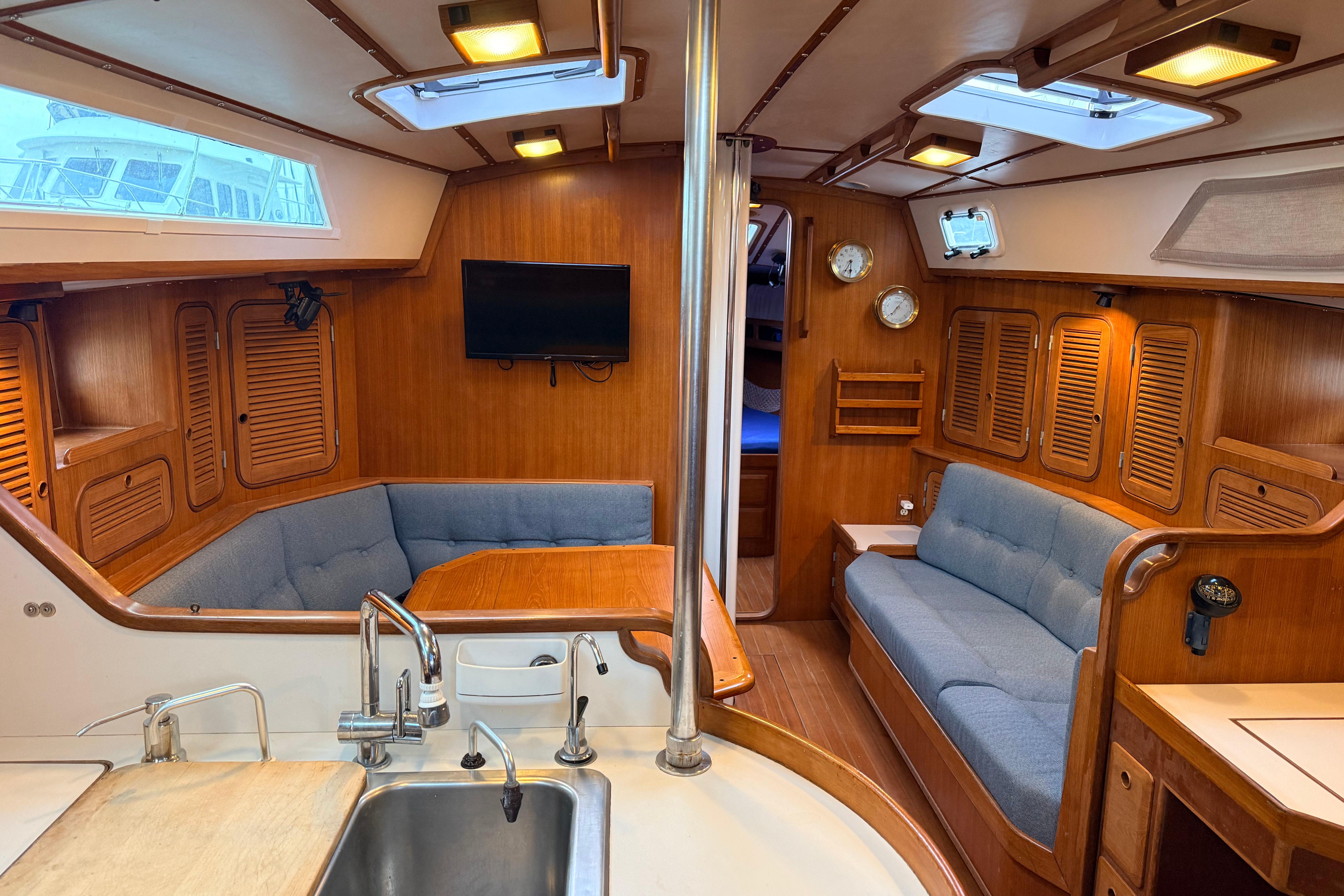 Interior of 1987 Norseman 400 yacht with wood paneling, seating, and kitchenette.