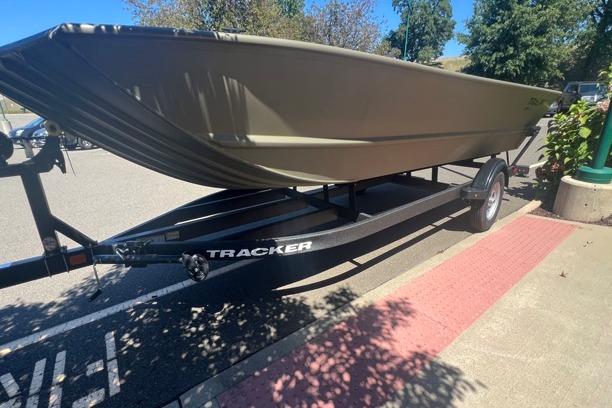 2026 Tracker GRIZZLY 2072 Utility boat on trailer in parking lot.