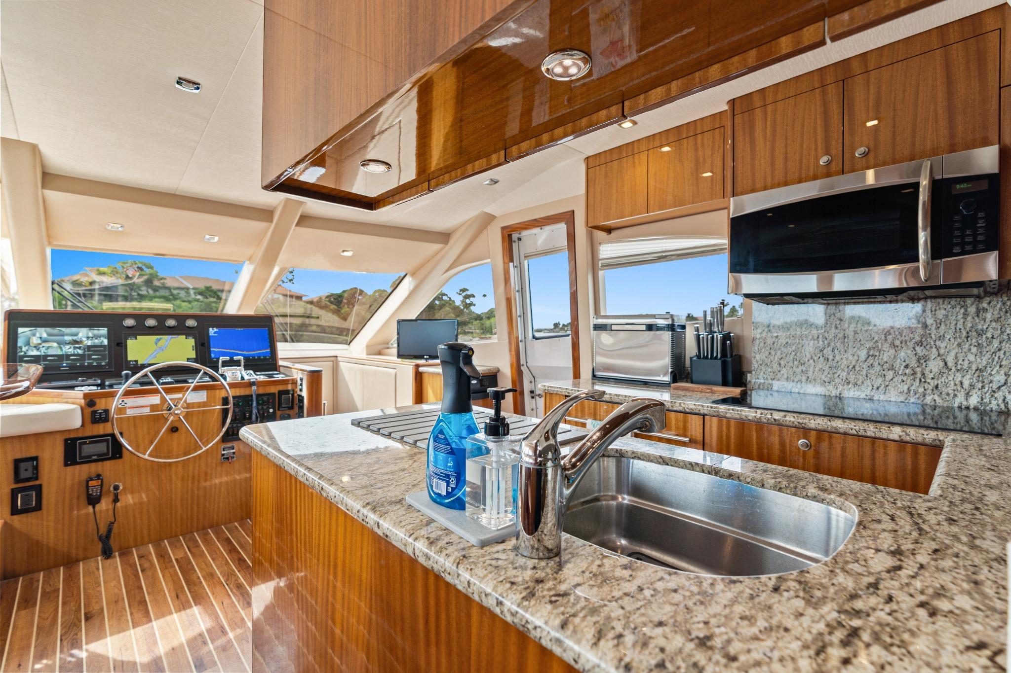 Luxurious interior of 2008 Hatteras 64 Motor Yacht with modern kitchen and helm.