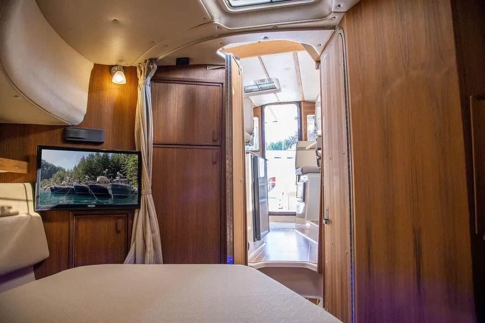 Interior of the 2023 Ranger Tugs R 31 LE with wood paneling and a TV.