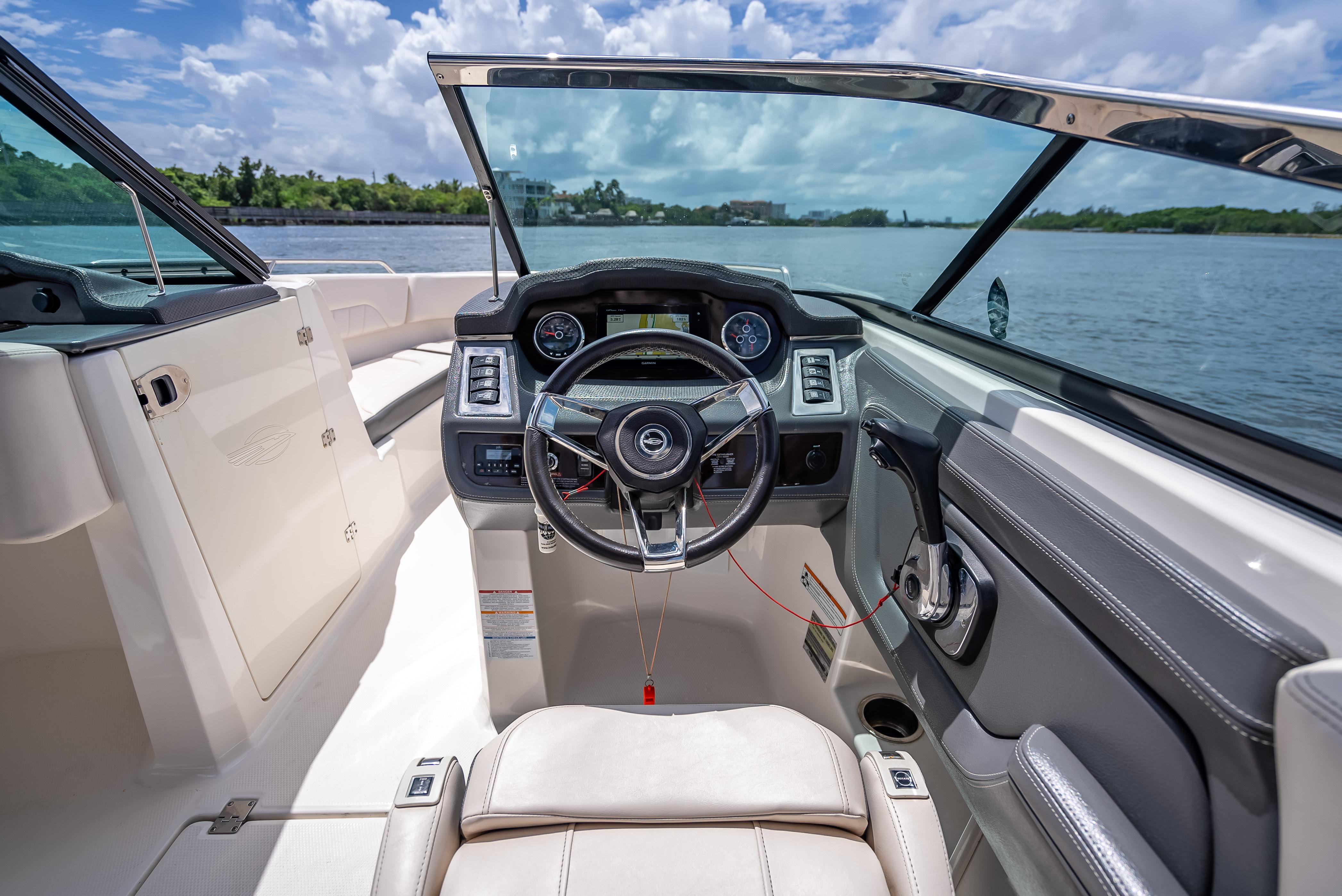 Interior view of 2017 Chaparral 227 SSX boat cockpit with steering wheel and dashboard.