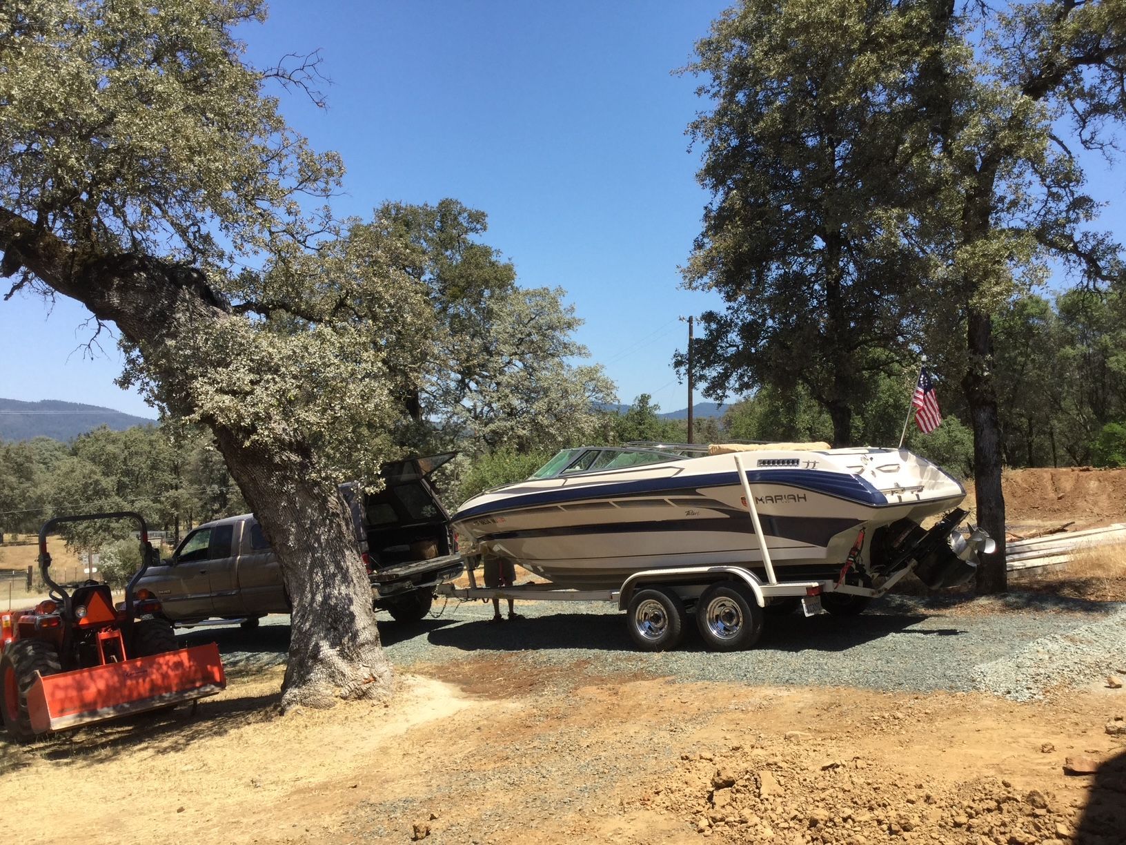 1996 Mariah Talari boat on trailer parked in forest.