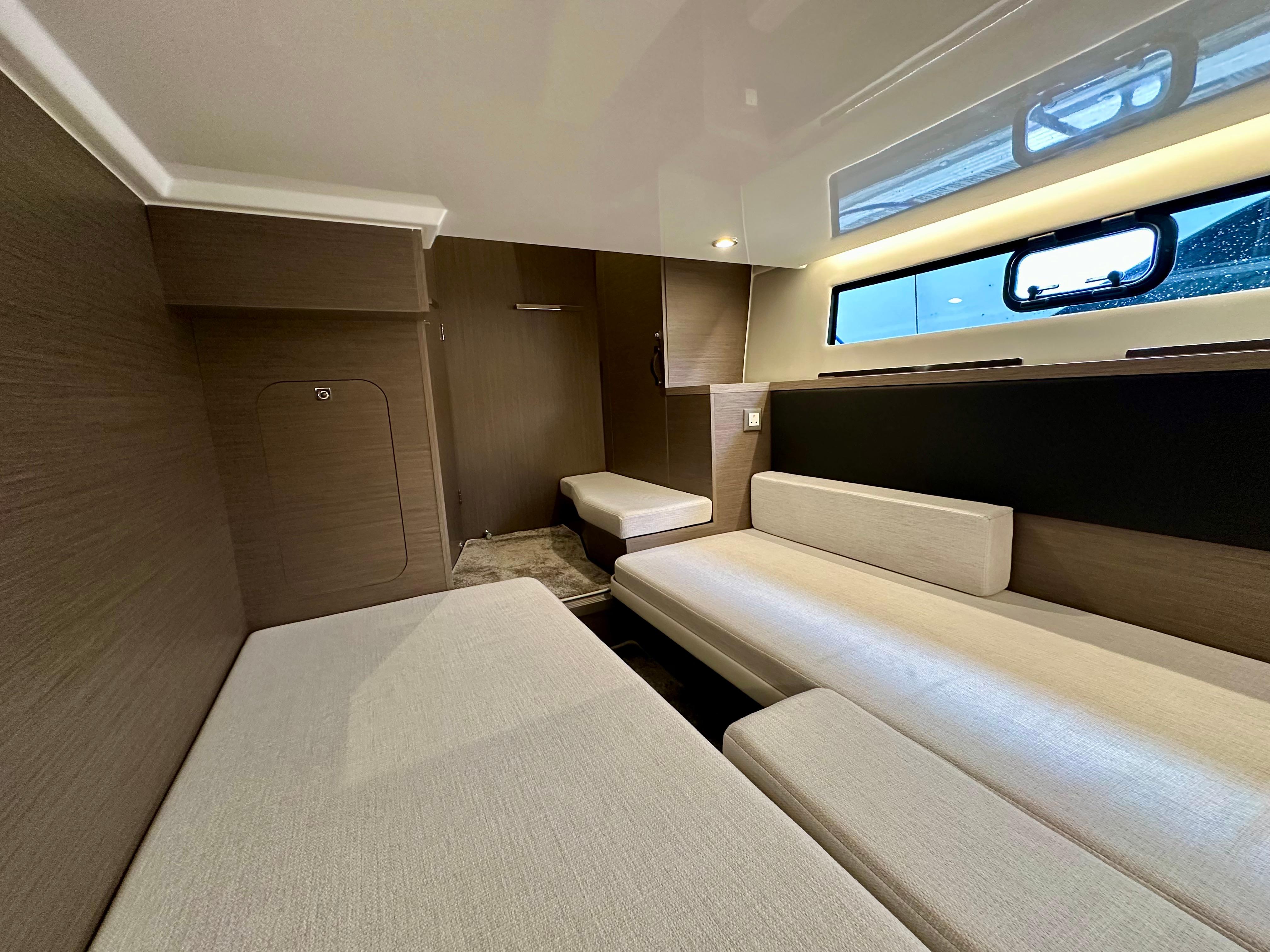 2024 Jeanneau Merry Fisher 1295 Flybridge interior with modern seating and window view.