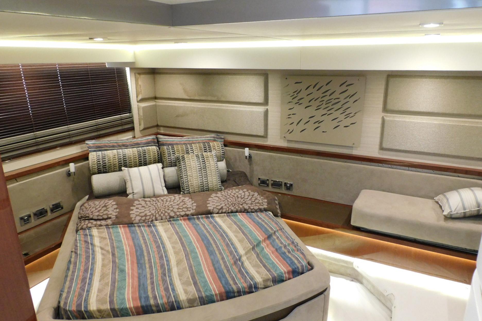 Luxurious 2019 Sea Ray L550 yacht bedroom with modern decor and comfortable bedding.