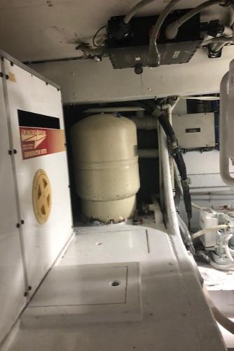 Engine room of a 1997 Bertram Convertible boat with machinery and equipment.