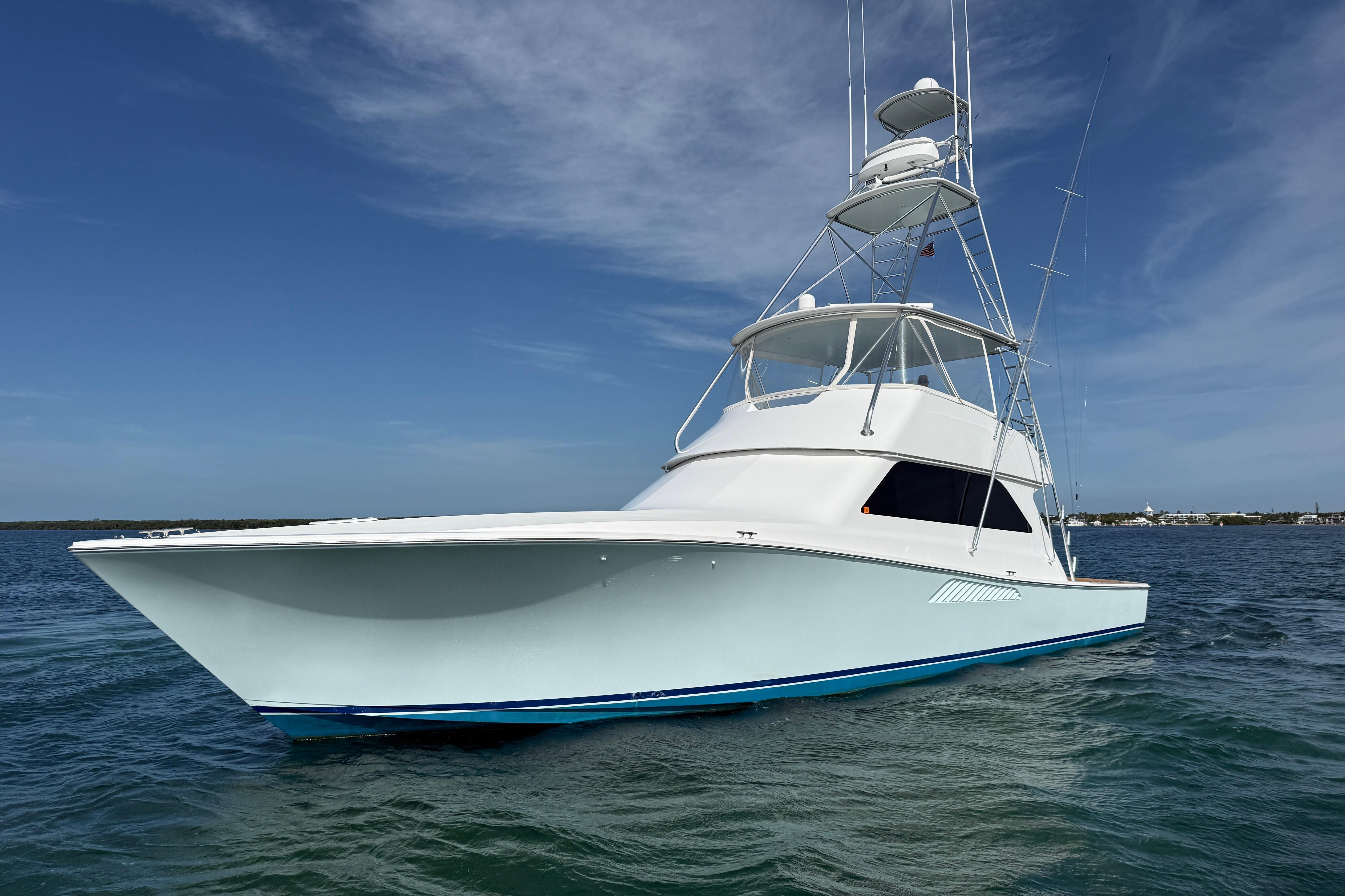 2000 Viking 55 Convertible yacht on calm water under clear blue sky.