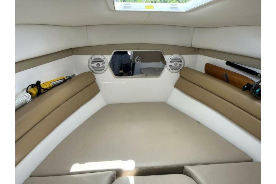 Interior cabin of 2006 Century 2400 Walk-Around boat with beige seating and speakers.