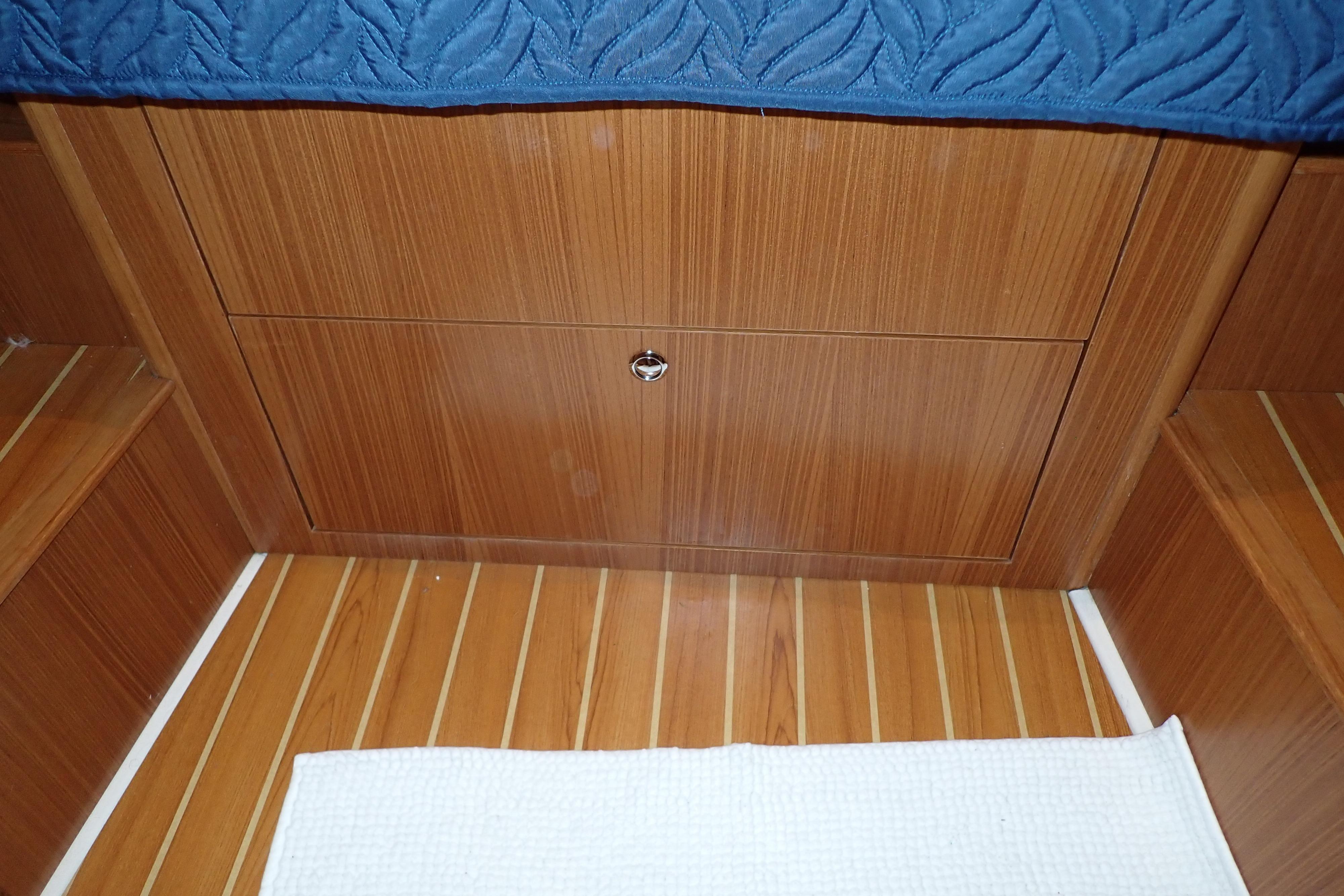 2023 True North 34 Outboard Express cabin interior with wooden flooring and storage.