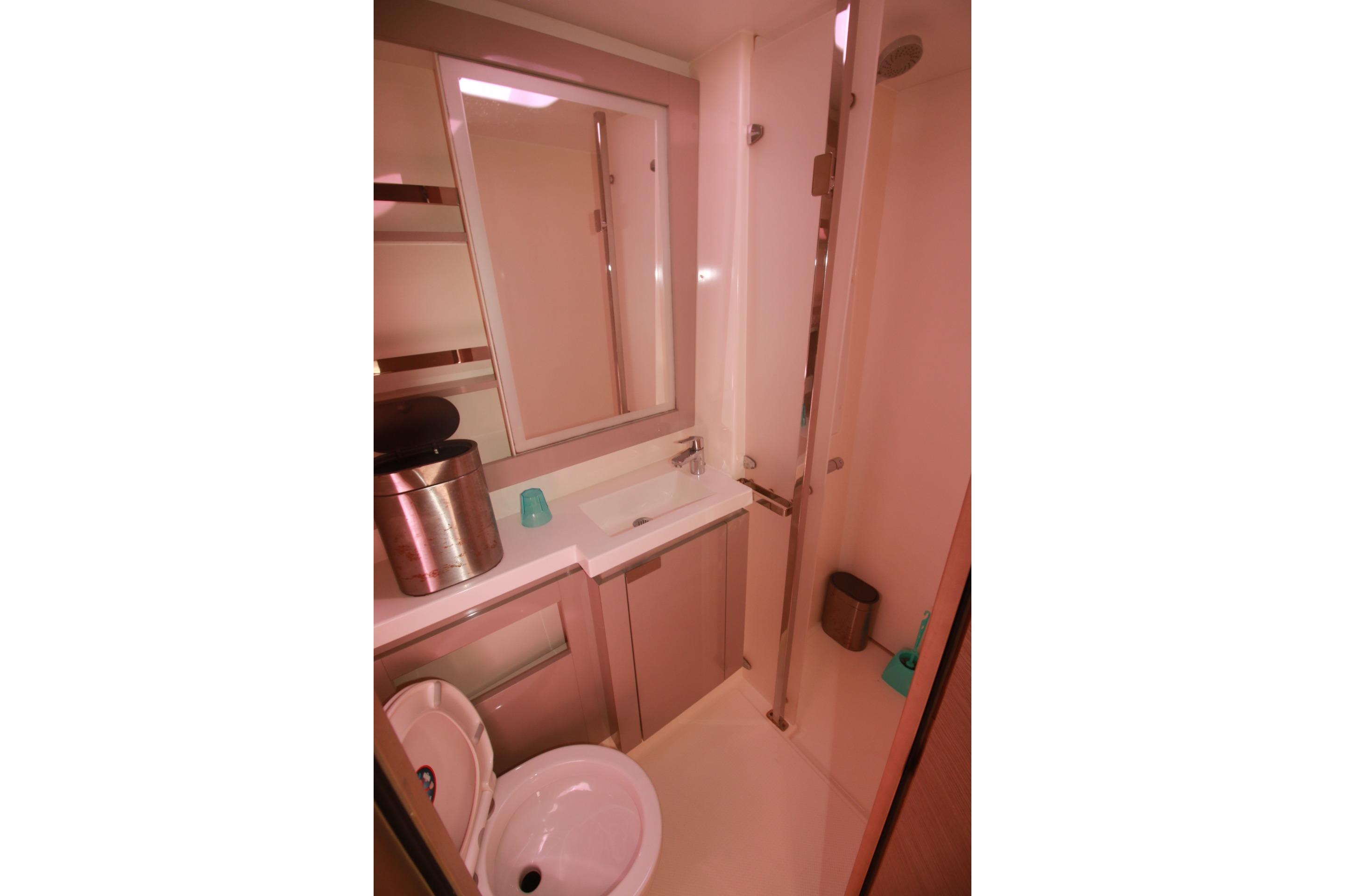 Modern bathroom in 2022 Fountaine Pajot Elba 45 Catamaran with sleek fixtures and mirror.