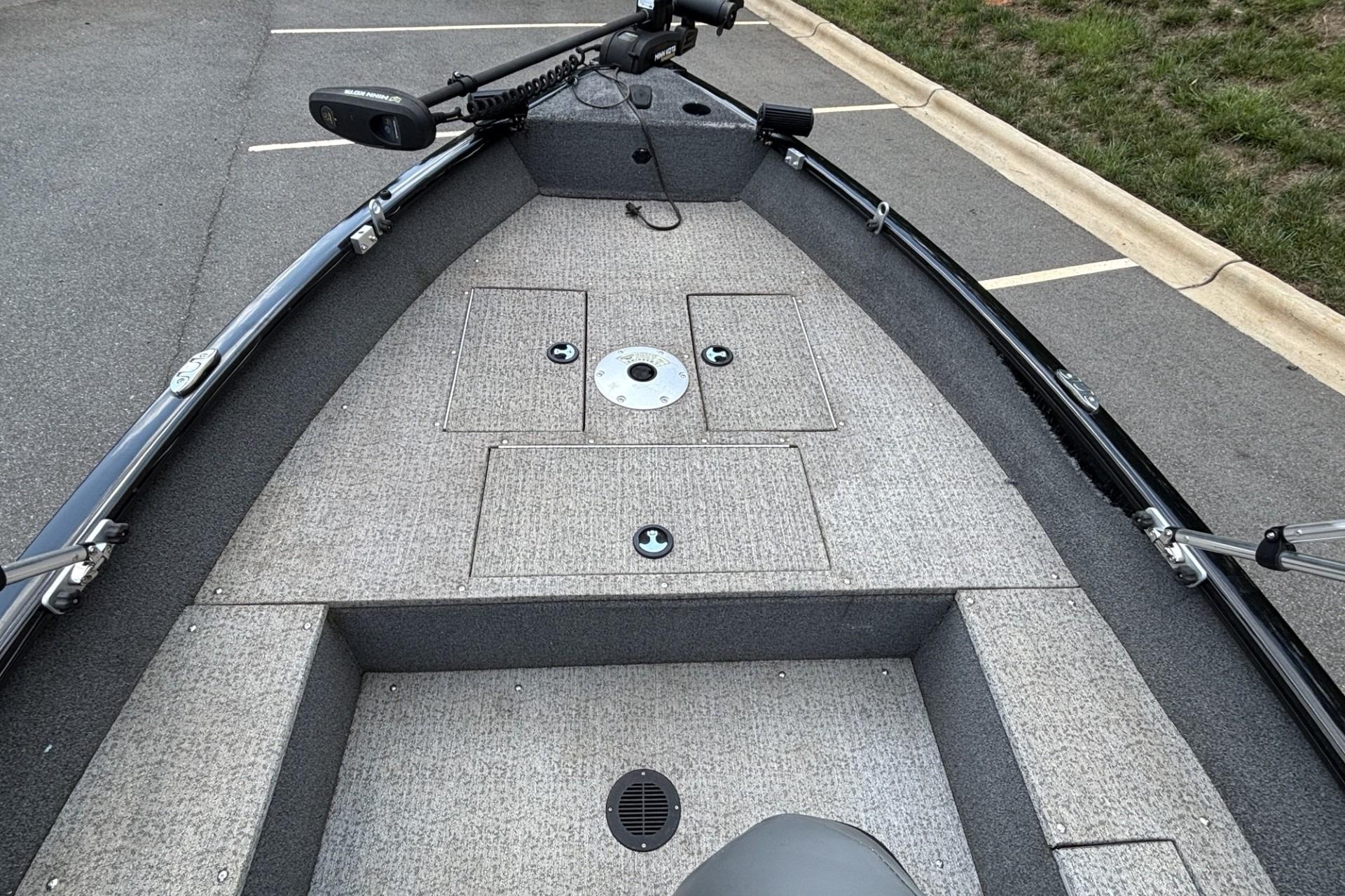 2022 Tracker Super Guide V-16 T boat interior with carpeted deck and storage compartments.
