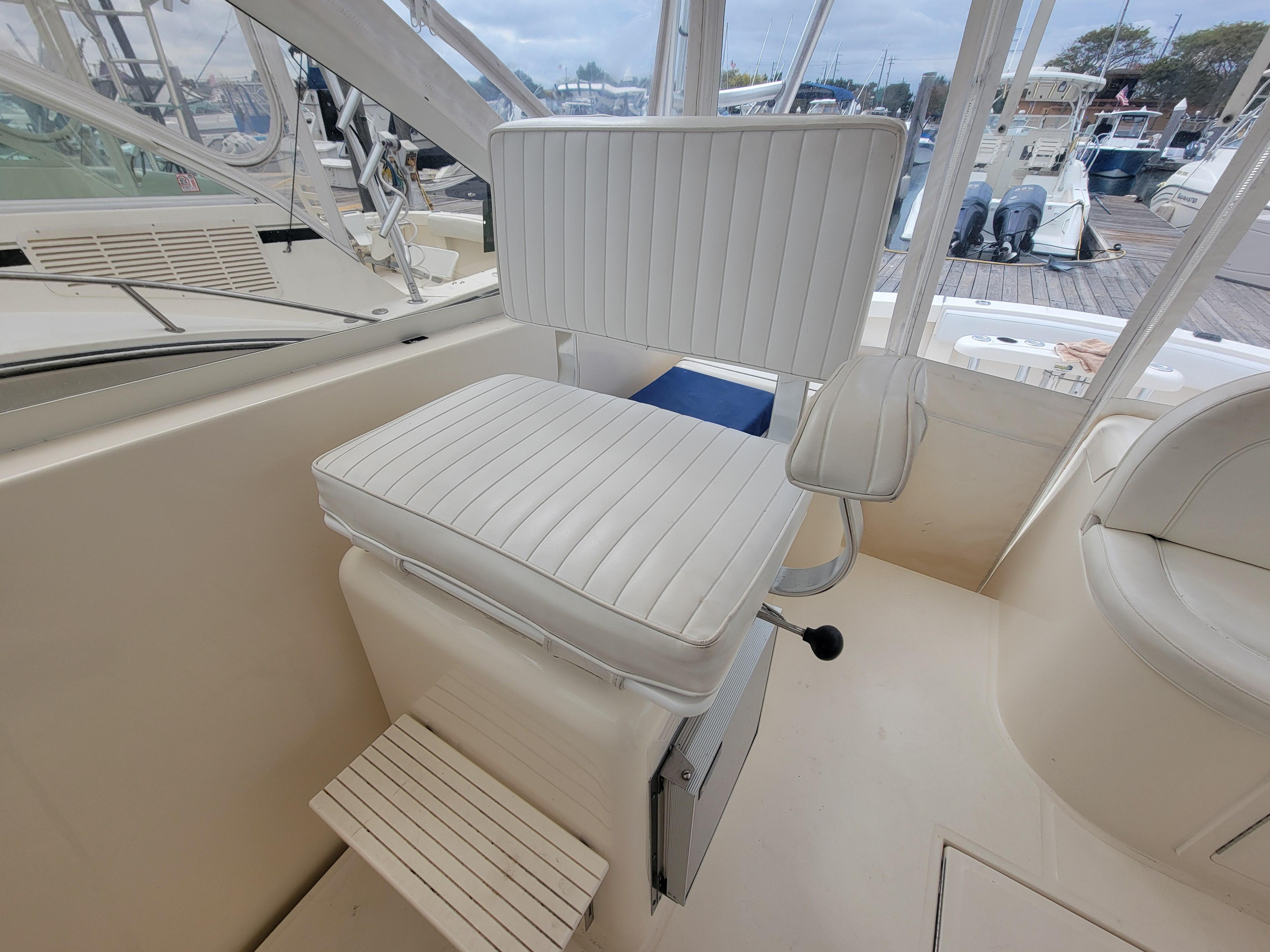 Captain's chair on 2006 Carolina Classic 32 Express boat, featuring white upholstery and footrest.