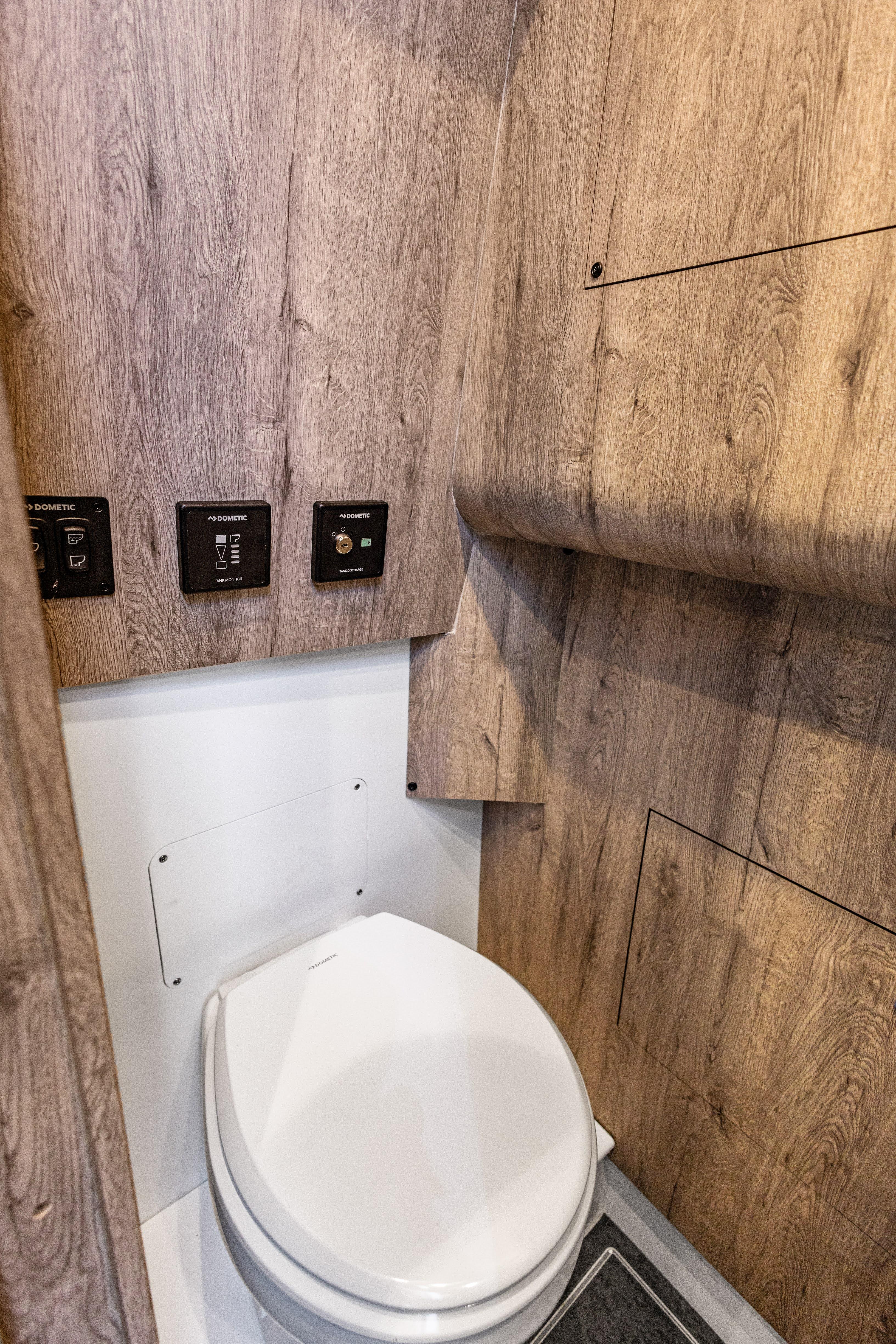 2026 Mystic Powerboats M4200 bathroom with wood paneling and modern fixtures.