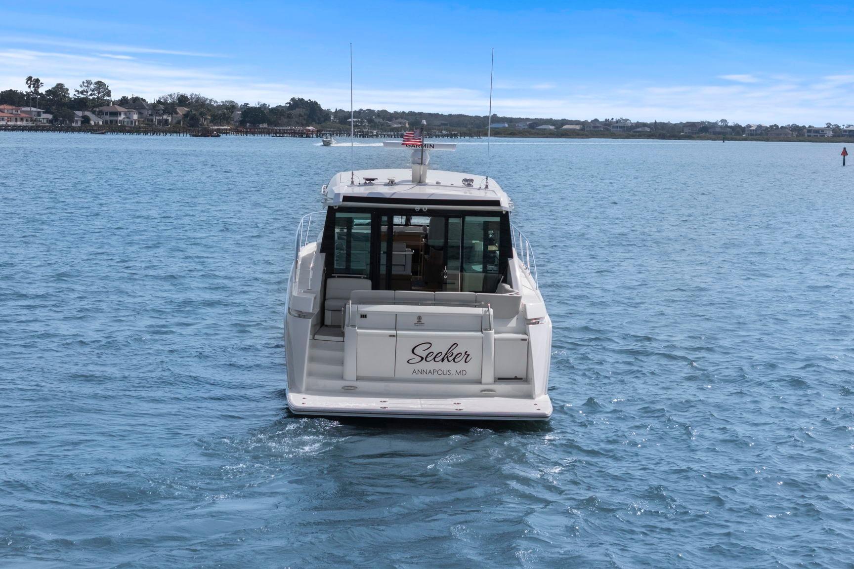 2023 Tiara Yachts C49 Coupe cruising on a serene blue waterway.