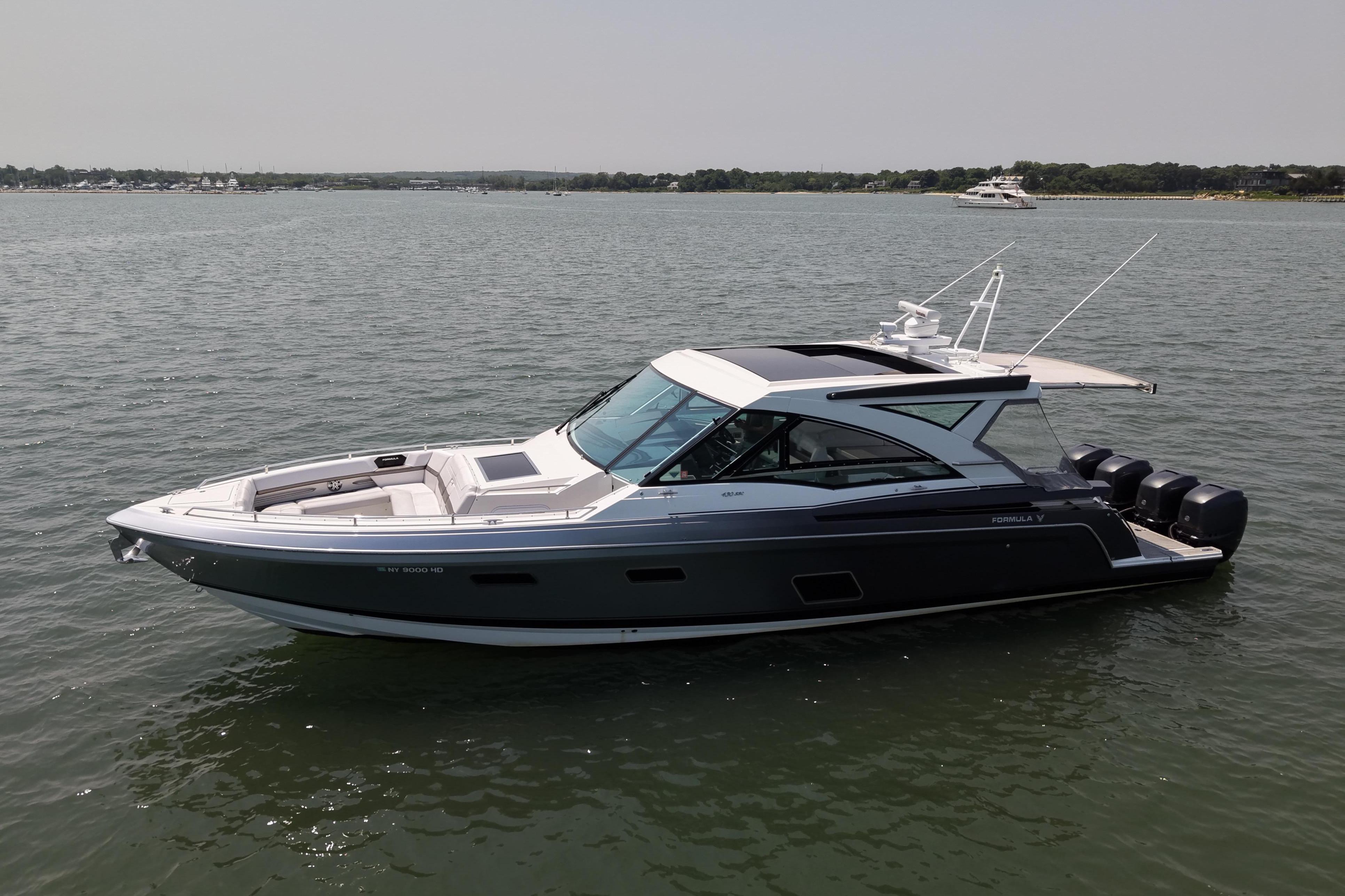 2019 Formula 430 Super Sport Crossover boat on calm water, side view.