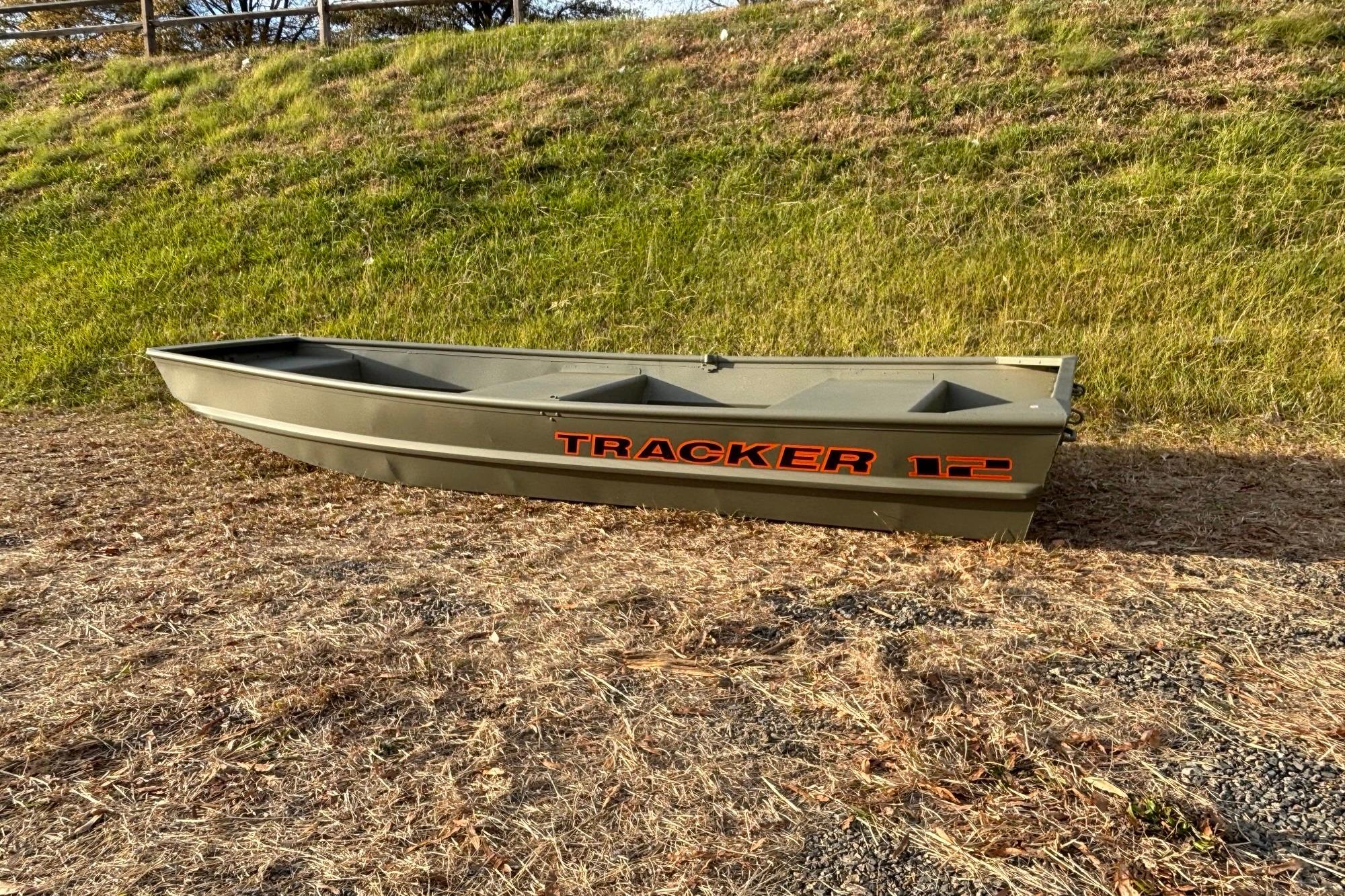 2026 Tracker Grizzly 12 Jon boat on grassy terrain, showcasing durable design.