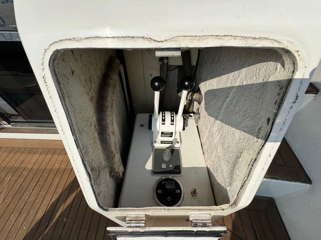 Control panel of a 1989 Birchwood 62 Cockpit Motor Yacht with levers and dials.