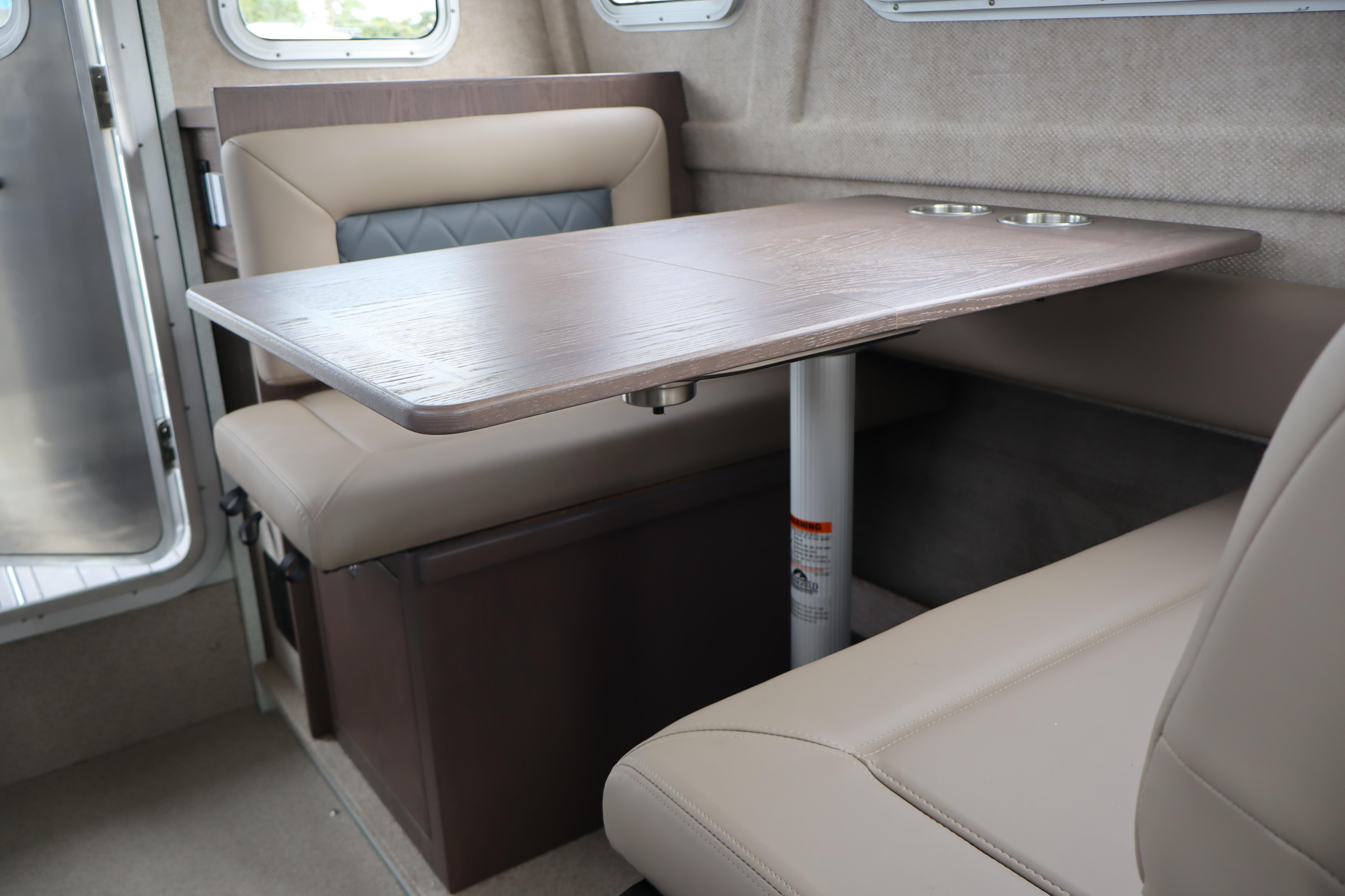 Interior of 2026 KingFisher 3025 XRS boat with beige seating and wooden table.