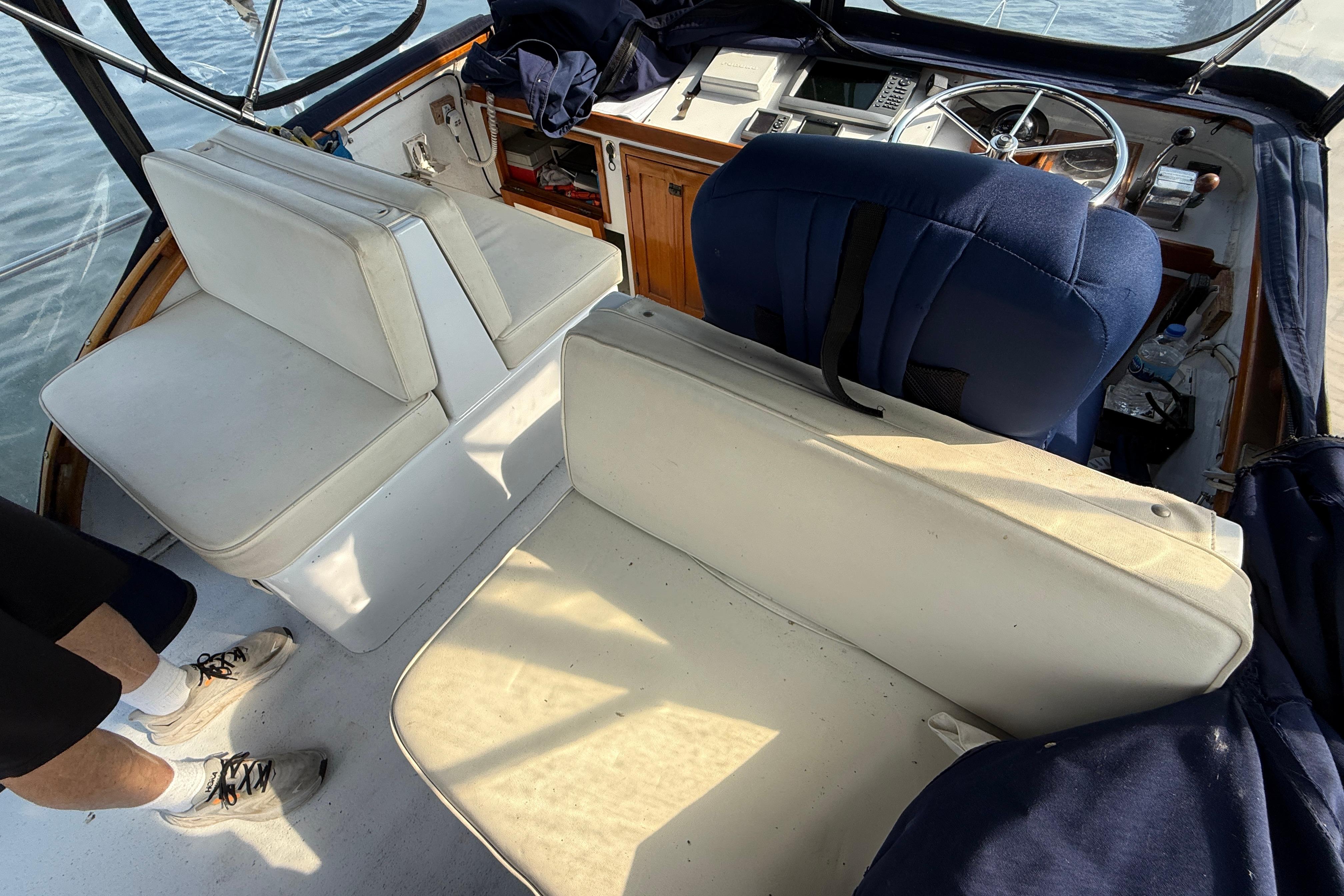 1983 Wilbur 34 Fly Bridge Cruiser interior with white seating and steering wheel.
