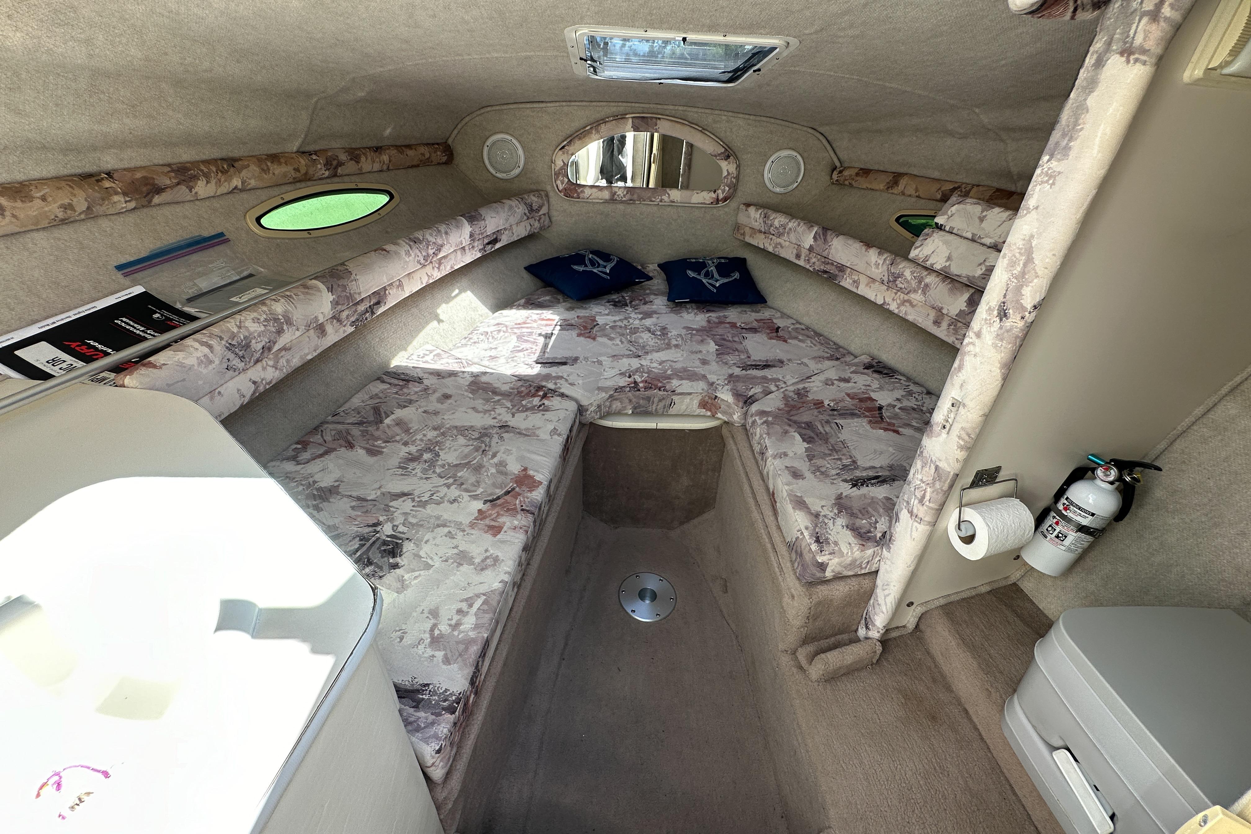 1998 Sea Ray 215 Express Cruiser cabin interior with seating, cushions, and amenities.