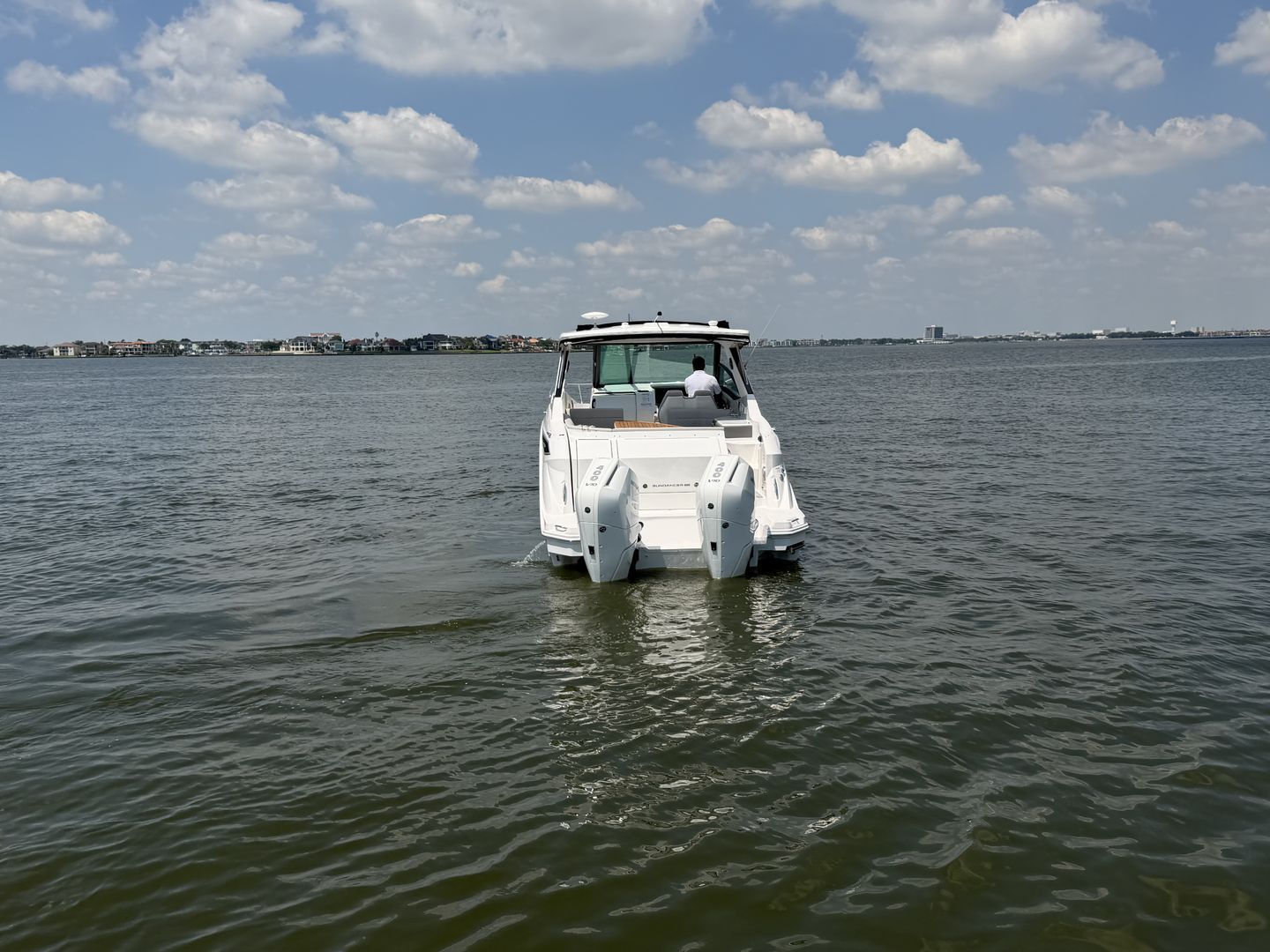 Sea Ray Sundancer 320 Outboard 2026 on calm water under blue sky.