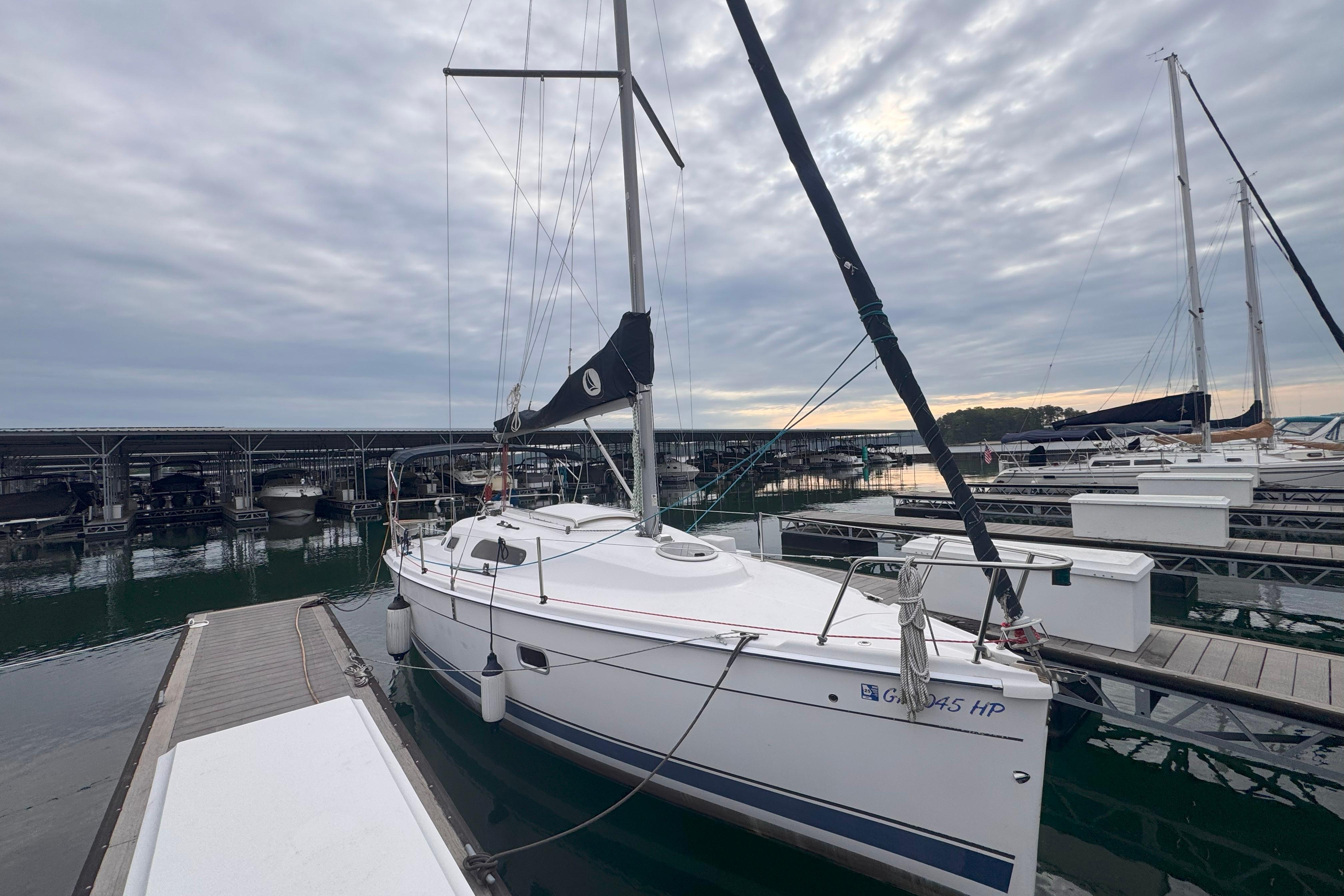 2007 Hunter 27 sailboat docked at marina under cloudy sky.