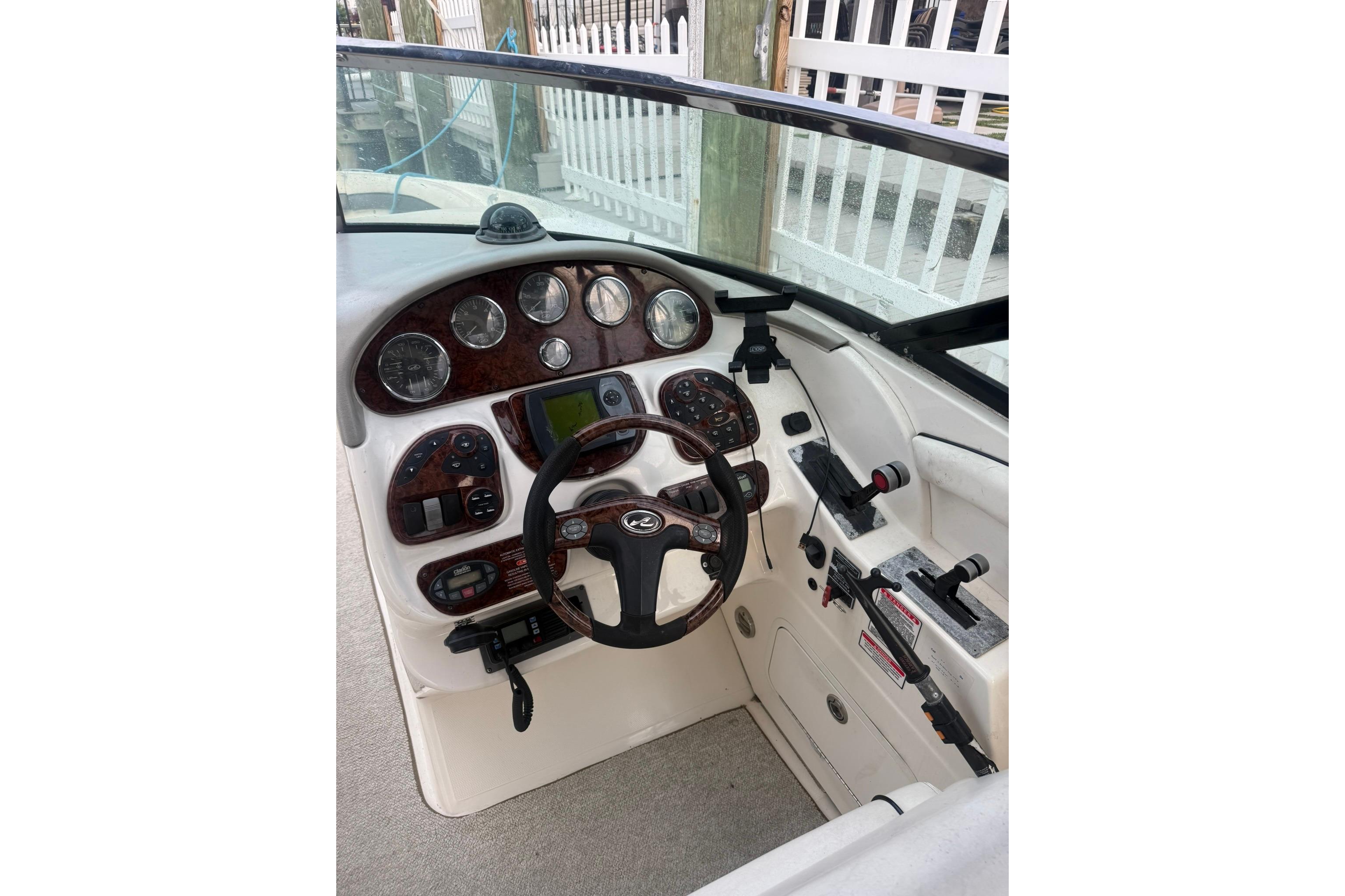2005 Sea Ray 290 SLX boat dashboard with steering wheel and control panel.
