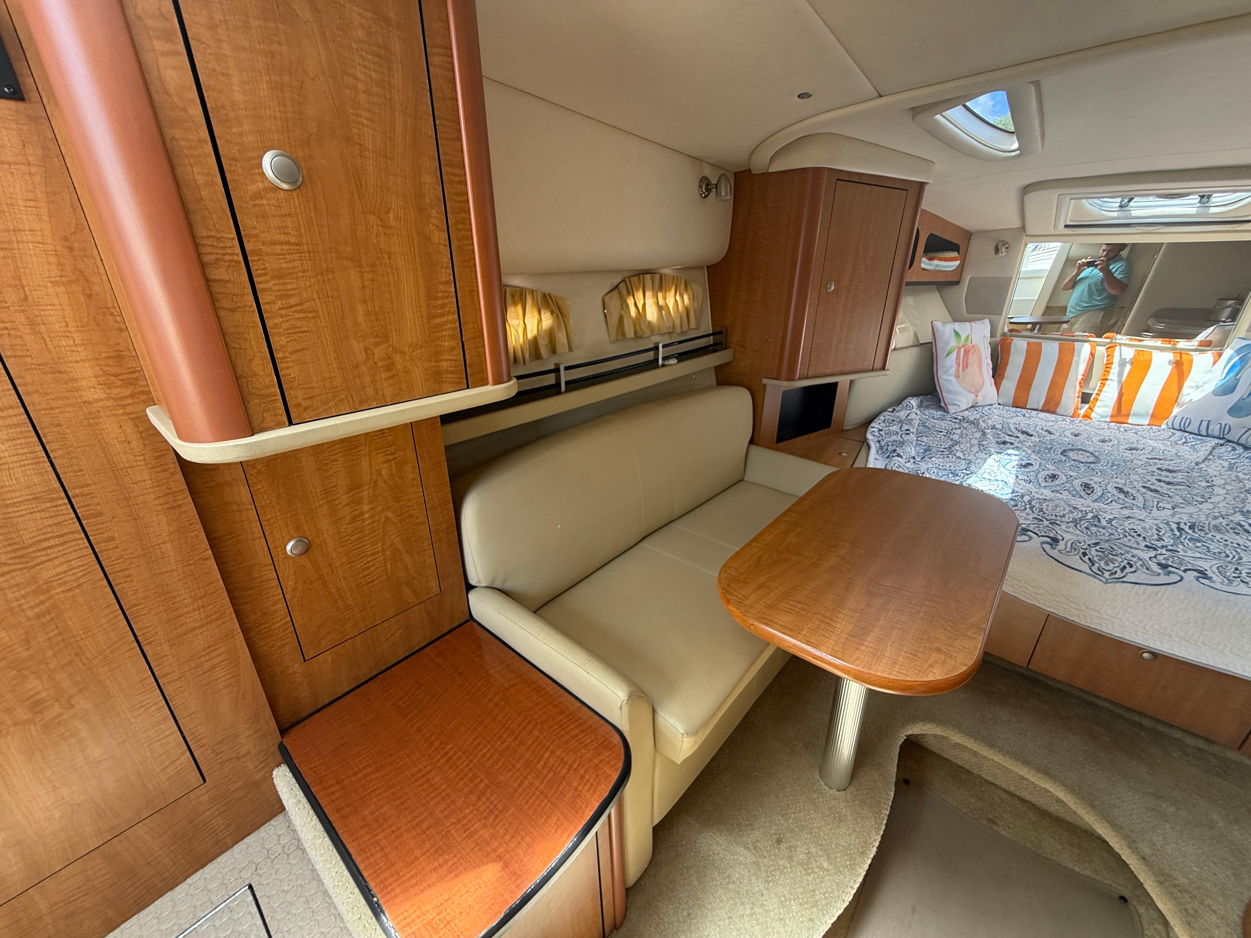 Interior of 2006 Sea Ray 290 Sundancer with seating, table, and bed.