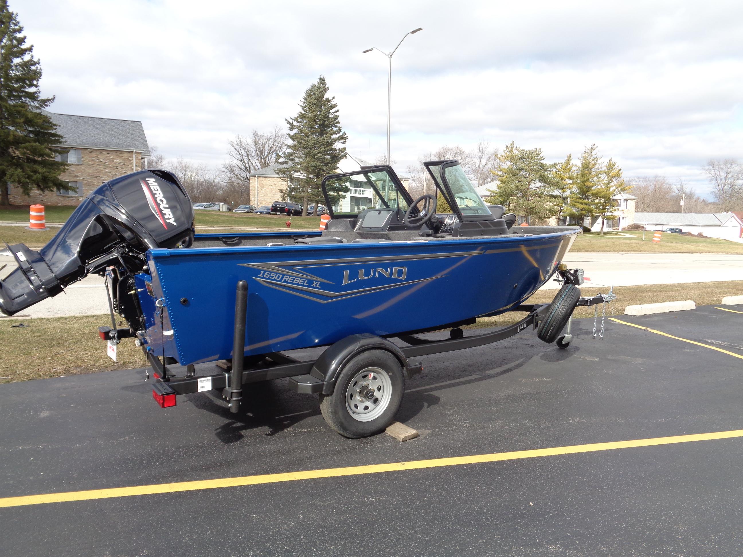 2024 Lund 1650 Rebel XL Sport boat on trailer, parked outdoors.