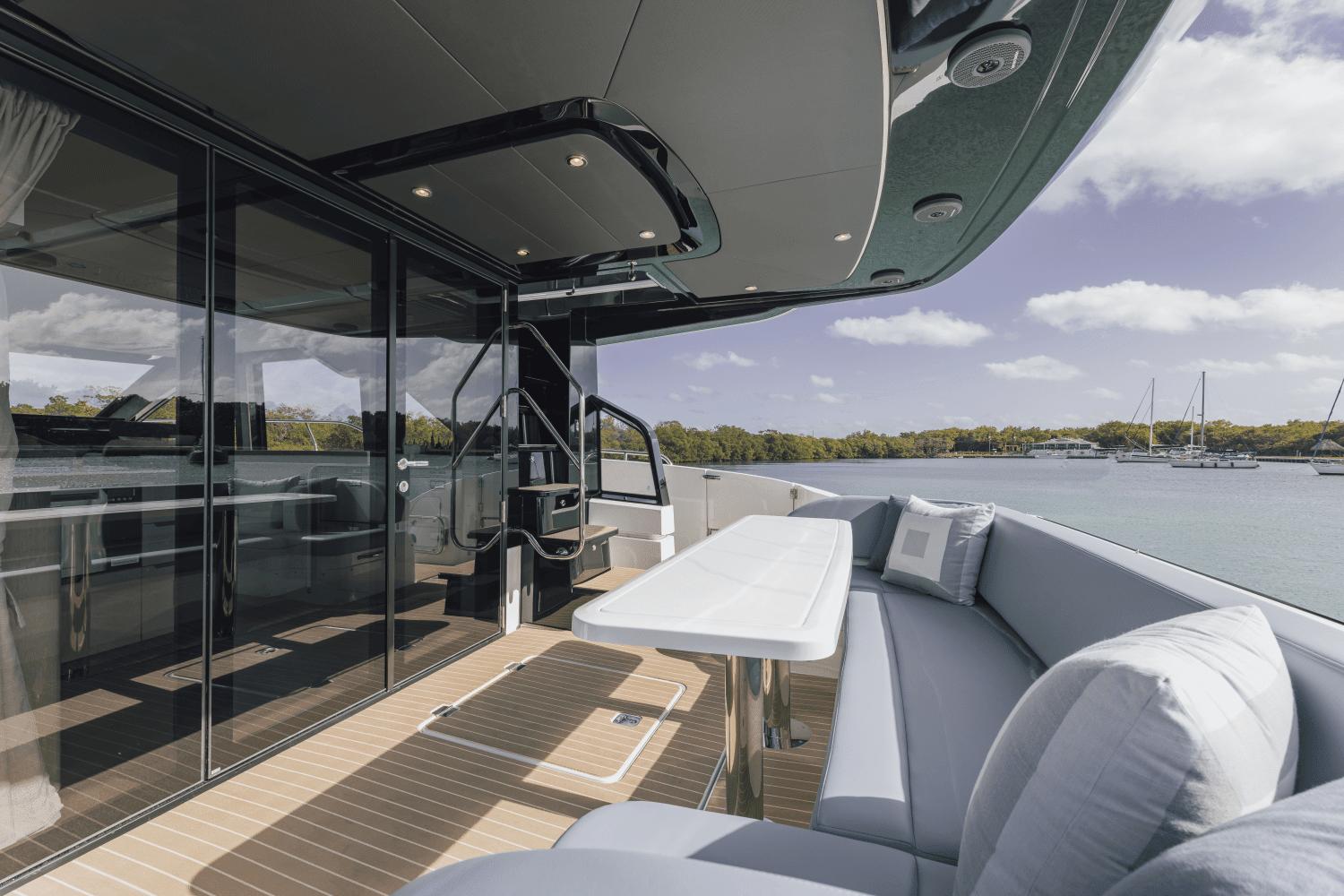 Luxurious 2025 Cruisers Yachts 57 Fly deck with elegant seating and scenic water view.
