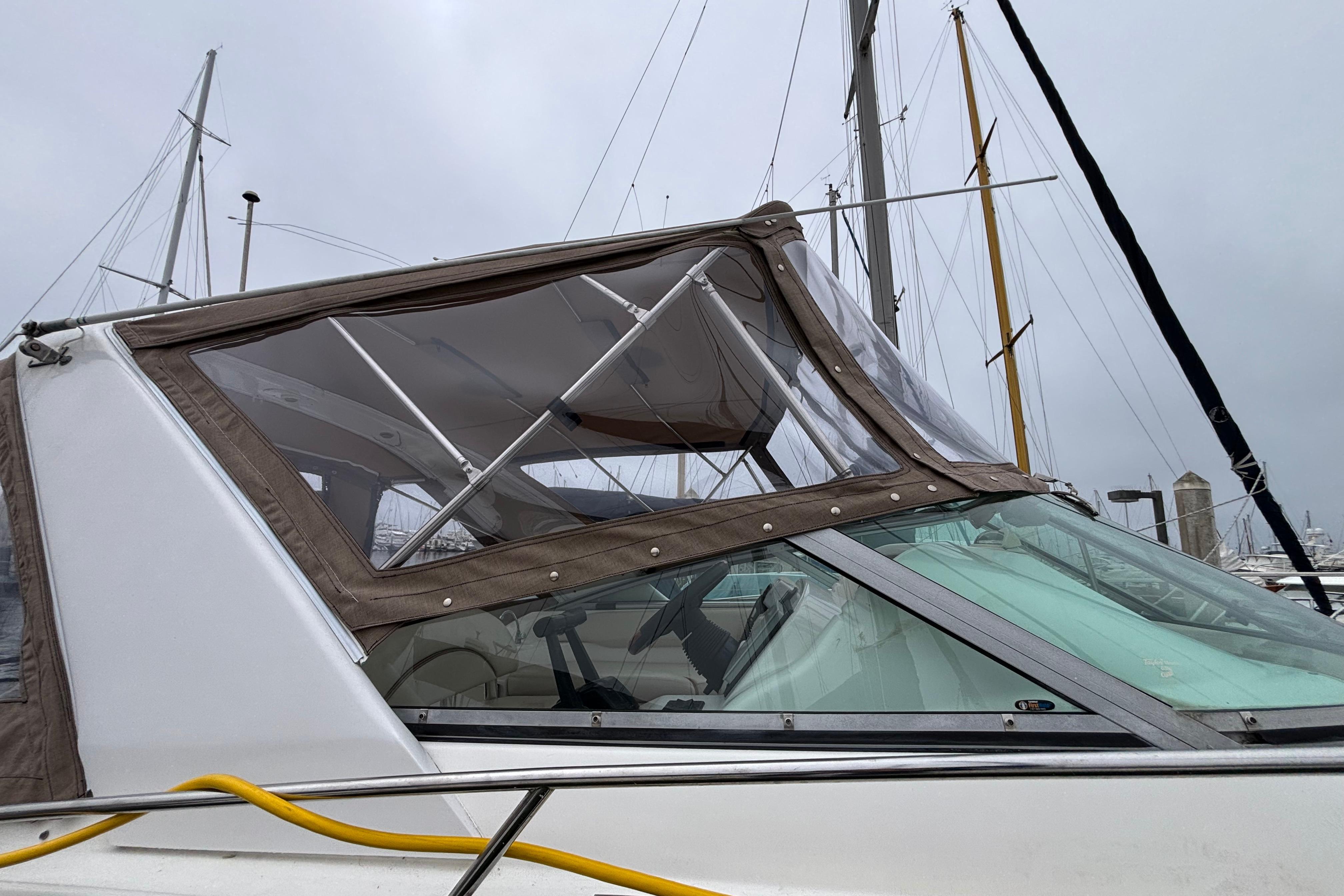 2004 Larson 310 boat with canopy, docked at marina under cloudy sky.