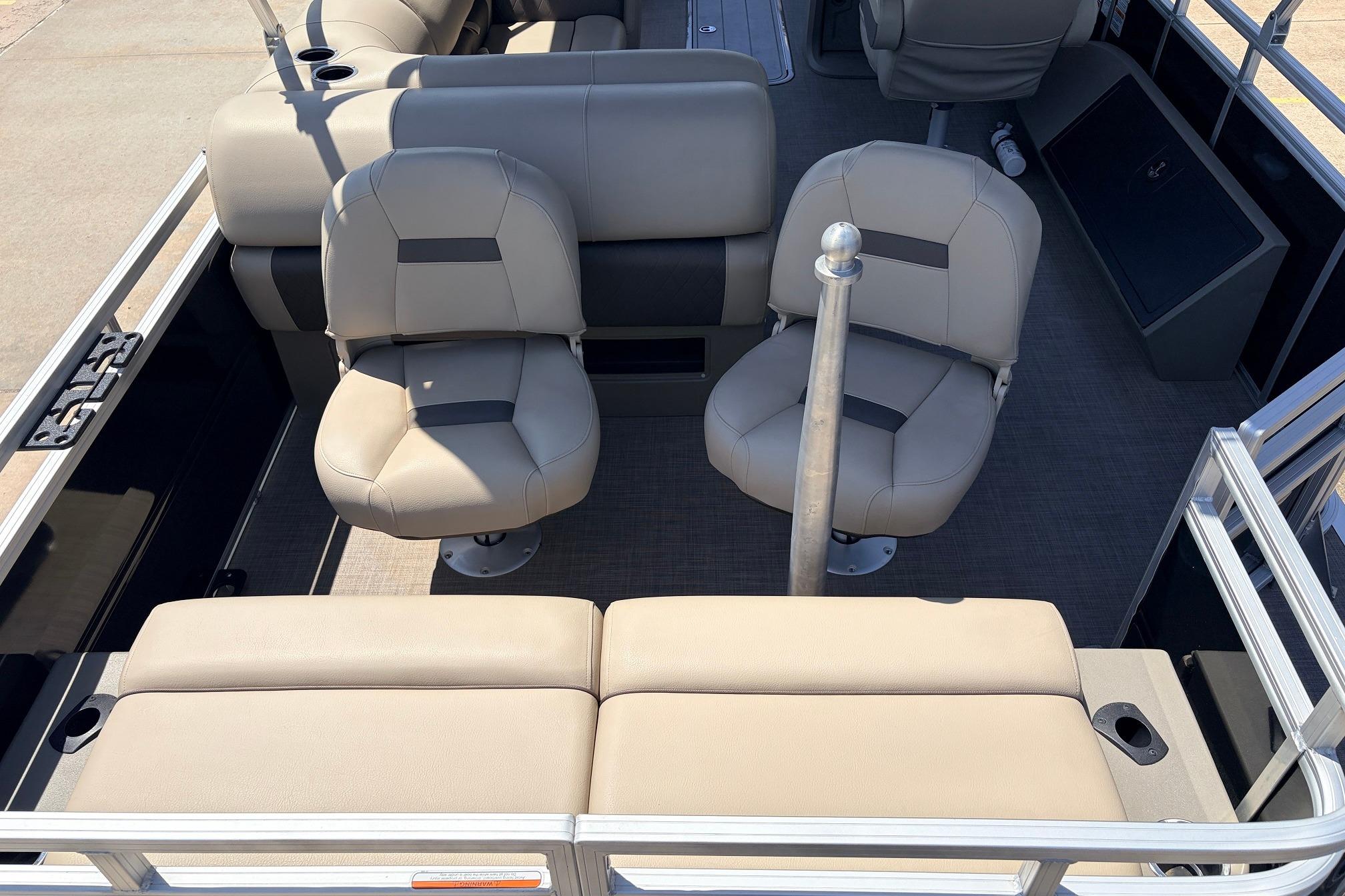 2024 Sun Tracker SportFish 22 XP3 interior with beige seating and fishing rod holder.