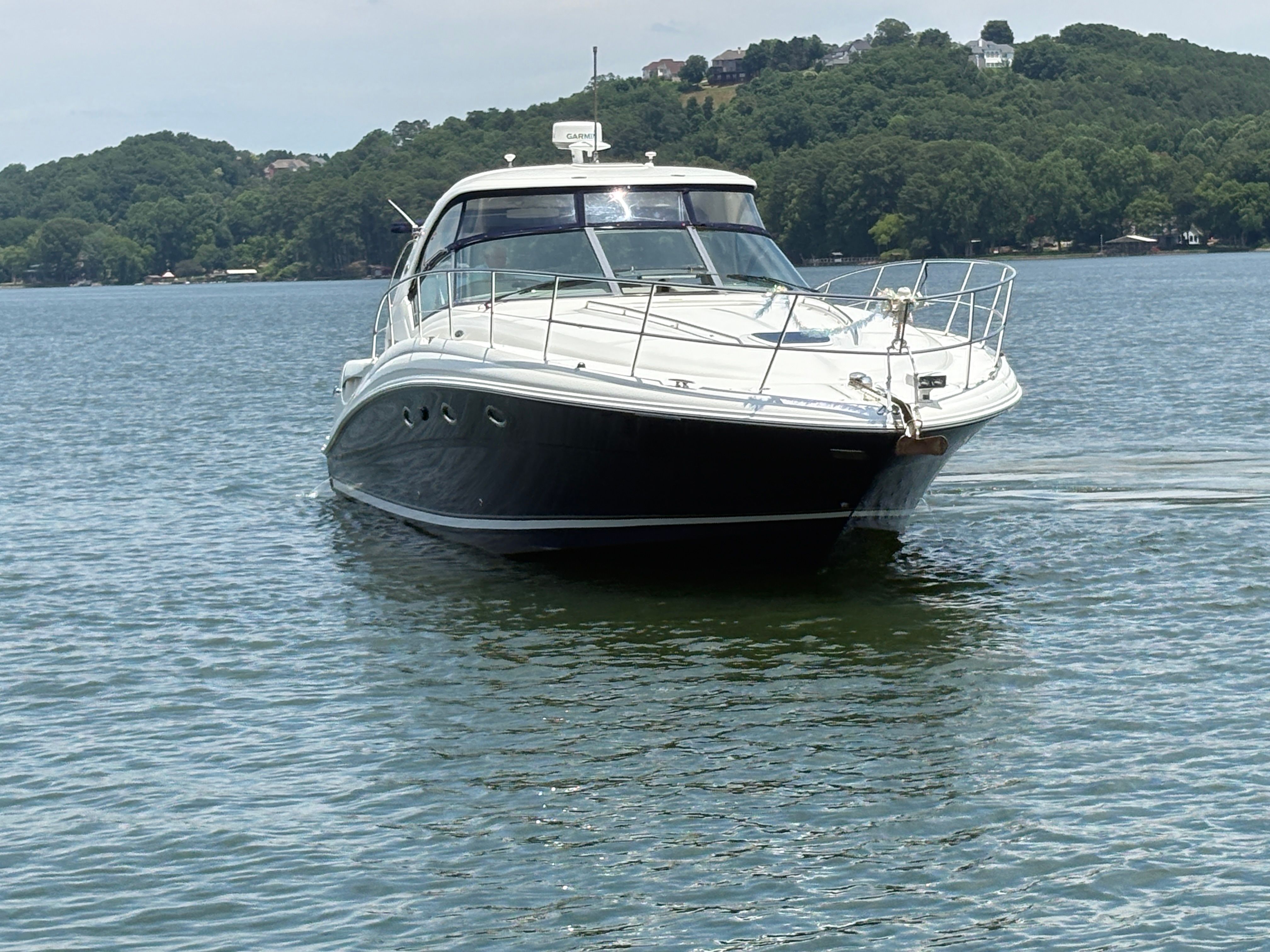 2005 Sea Ray 420 Sundancer on calm water with green landscape.