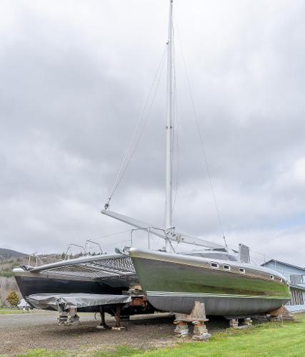 2025 Shuttleworth 52 AeroRig sailboat on land, cloudy sky background.