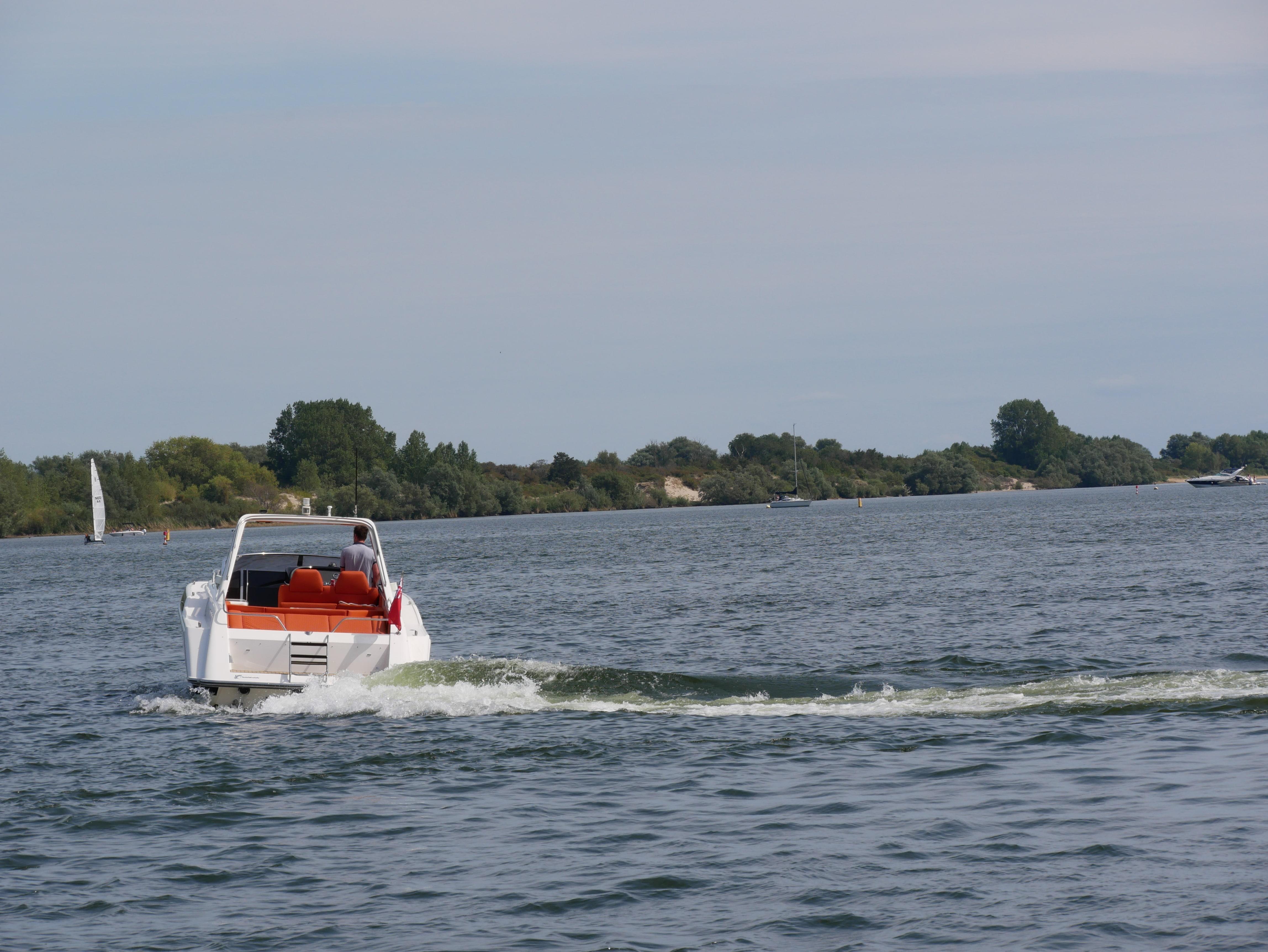 1991 Sunseeker Thunderhawk 43 cruising on a calm lake with distant shoreline.