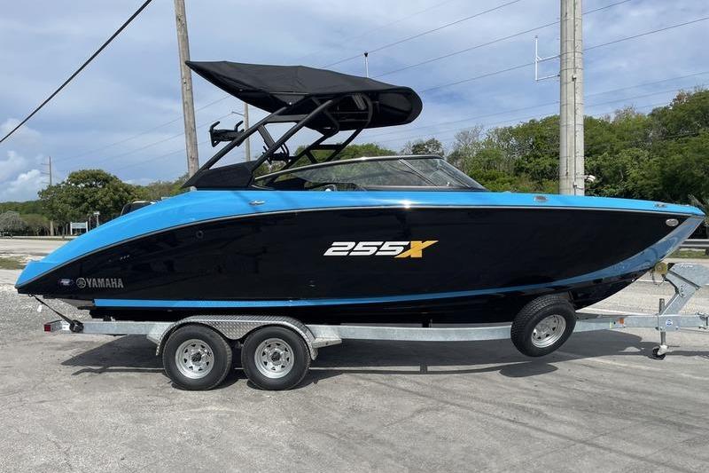 2023 Yamaha Boats 255XD on trailer, black and blue design, parked outdoors.